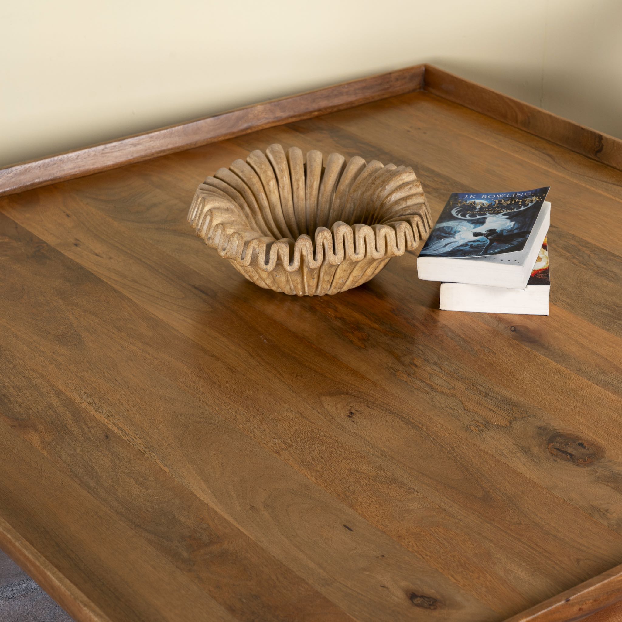 Close up image of a rustic square mango wood coffee table with raised edge, vintage-style entryway or living room furniture, 120×120×40 cm.