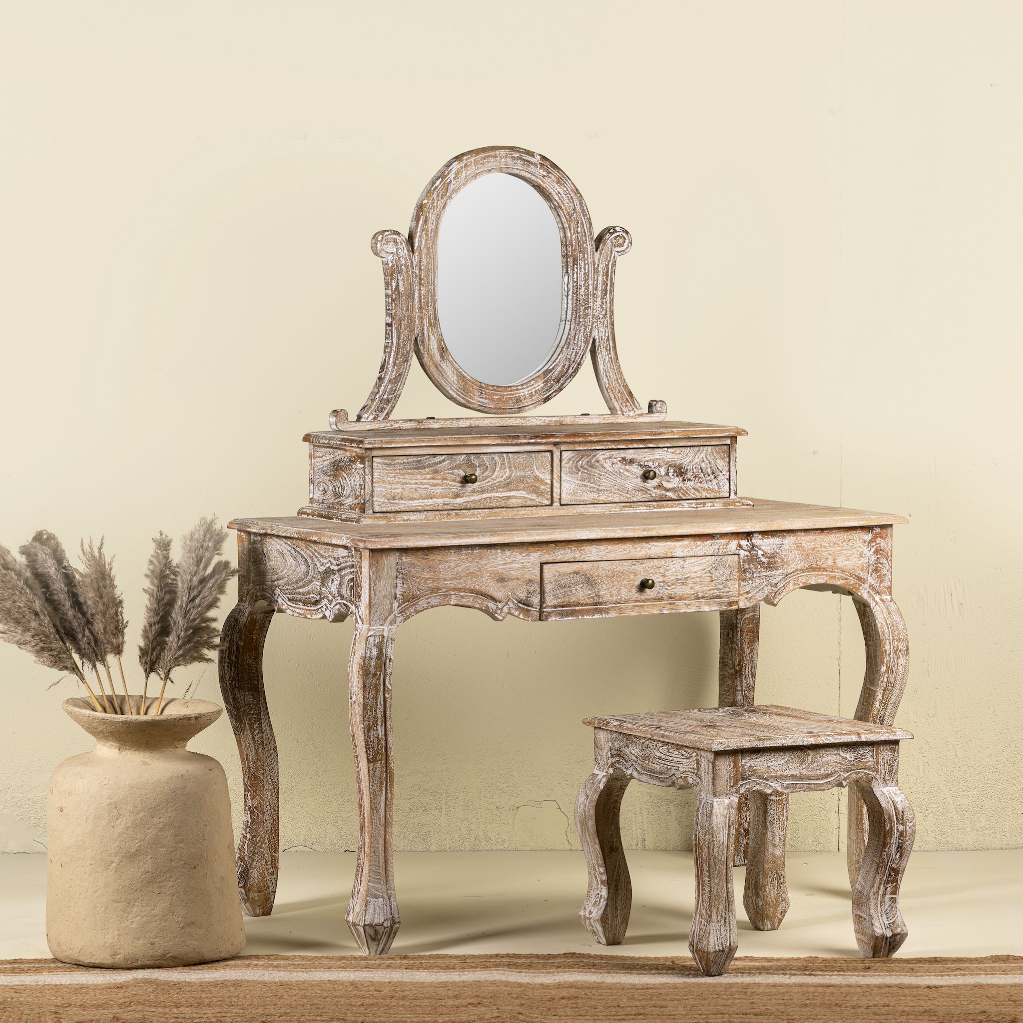 A handcrafted mango wood cosmetic table with a curved mirror and matching stool, showcasing a vintage style with a beige finish.