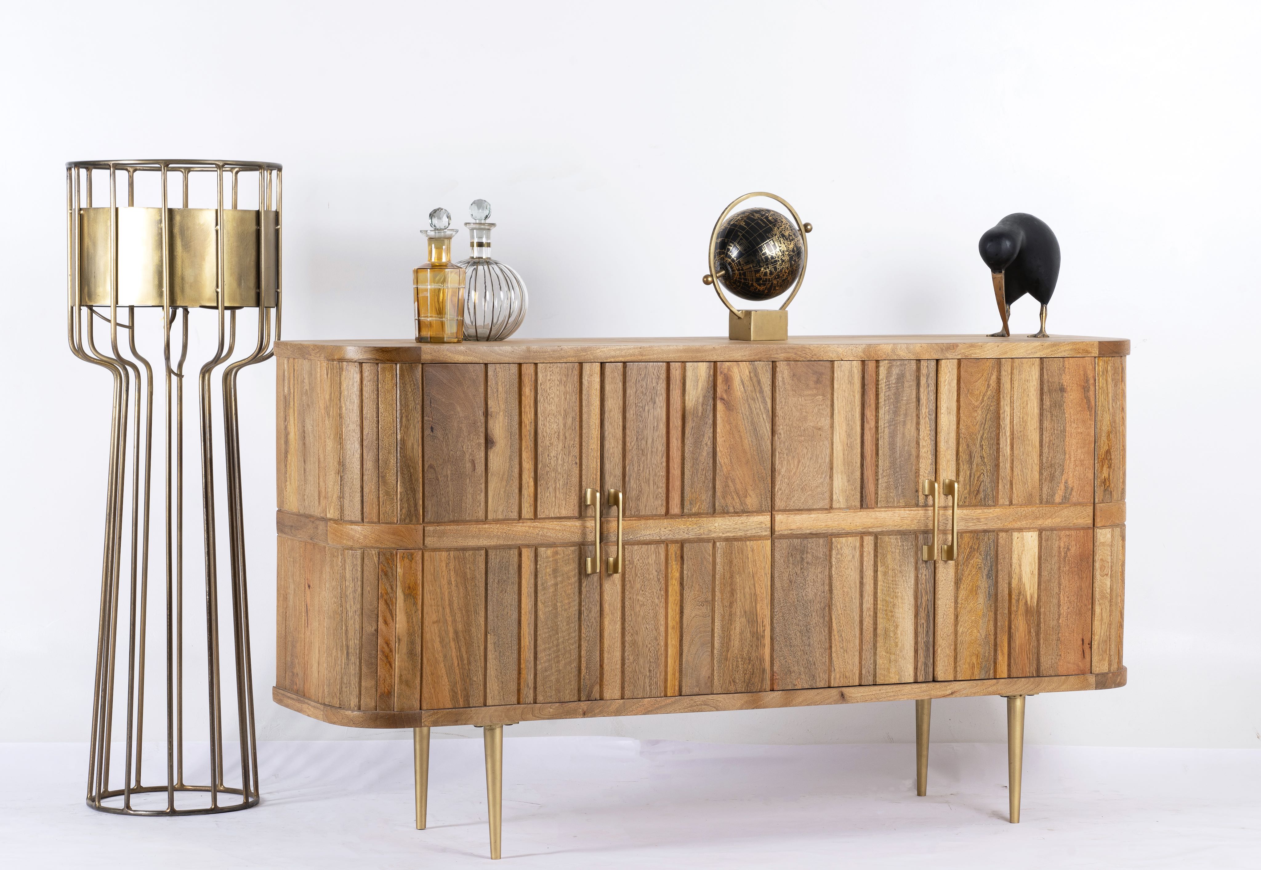 Side angle image of a handcrafted mango wood sideboard with curved door panels and brass-plated legs—minimalistic style living room furniture with natural elegance.