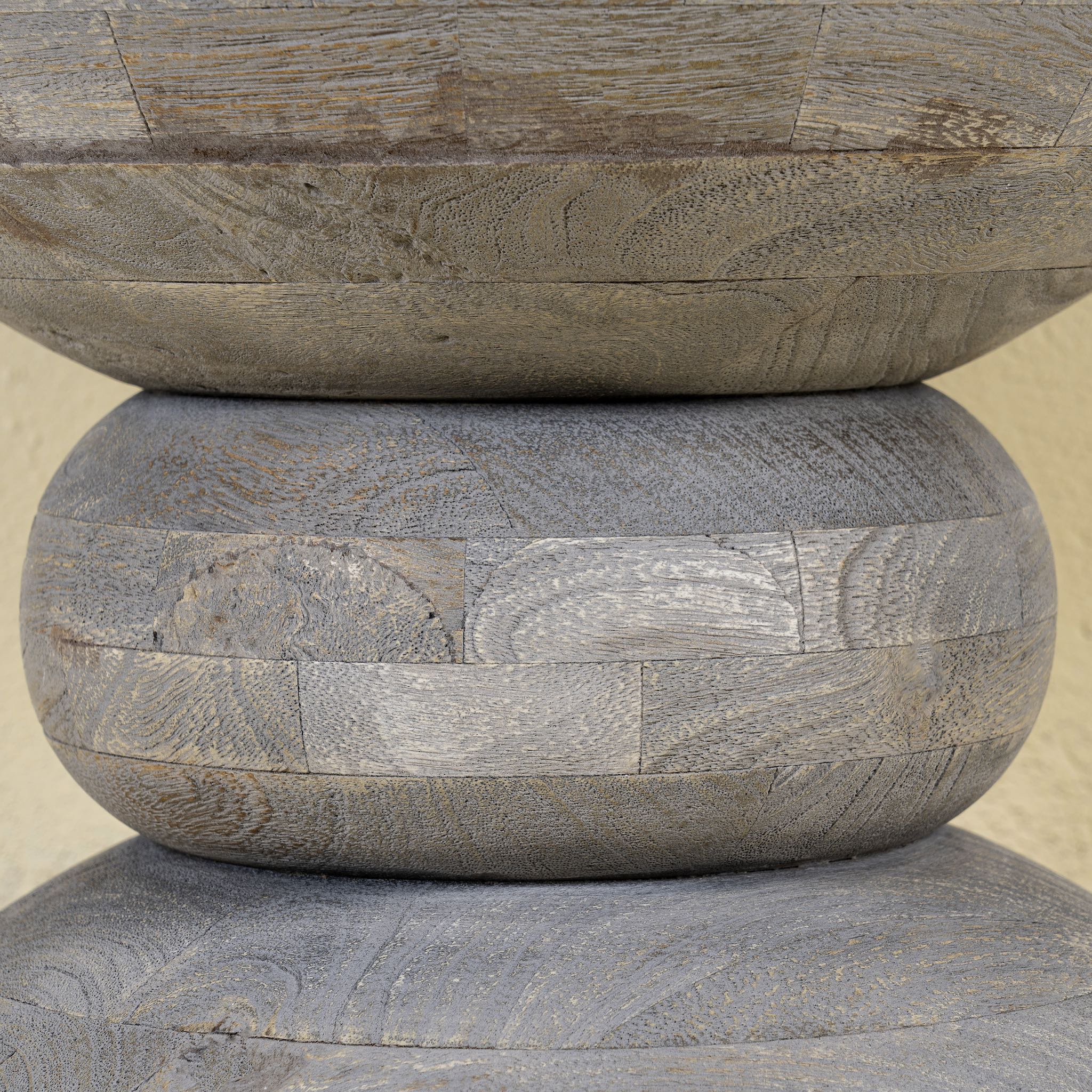 Close up image of a vintage style mango wood coffee table with rounded form and grey-washed finish; compact rustic accent table, 40 cm diameter, 46 cm height.