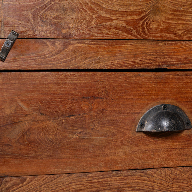 Close up image of an antique reclaimed teak wood display cabinet with glass door, honey wax finish, and lower drawer – unique furniture showcasing traditional Indian craftsmanship.