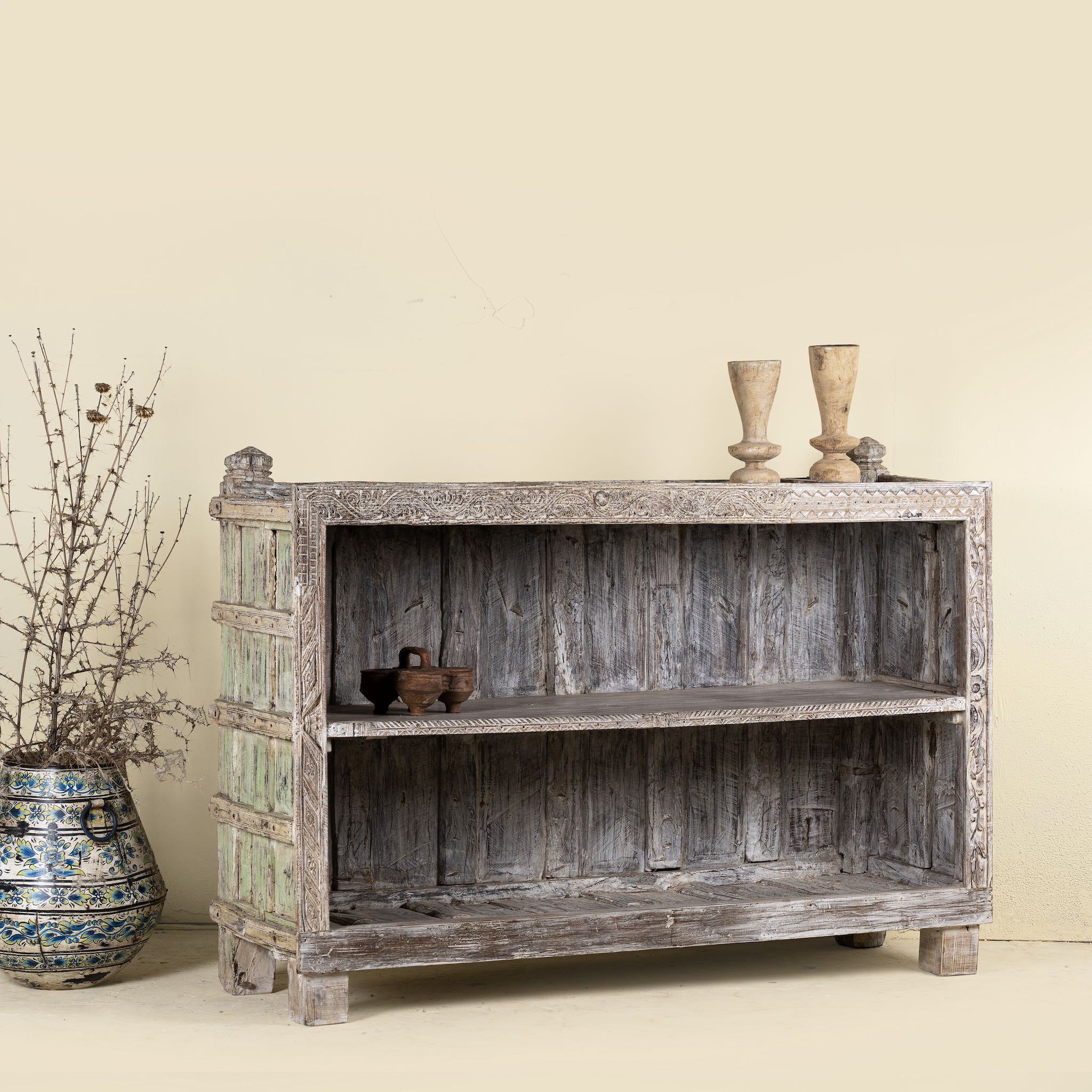 Back side image of an unique Indian furniture teak counter table with vintage shelving and aged green paint, antique console with original wood panel detailing, 152 × 64 × 102 cm.