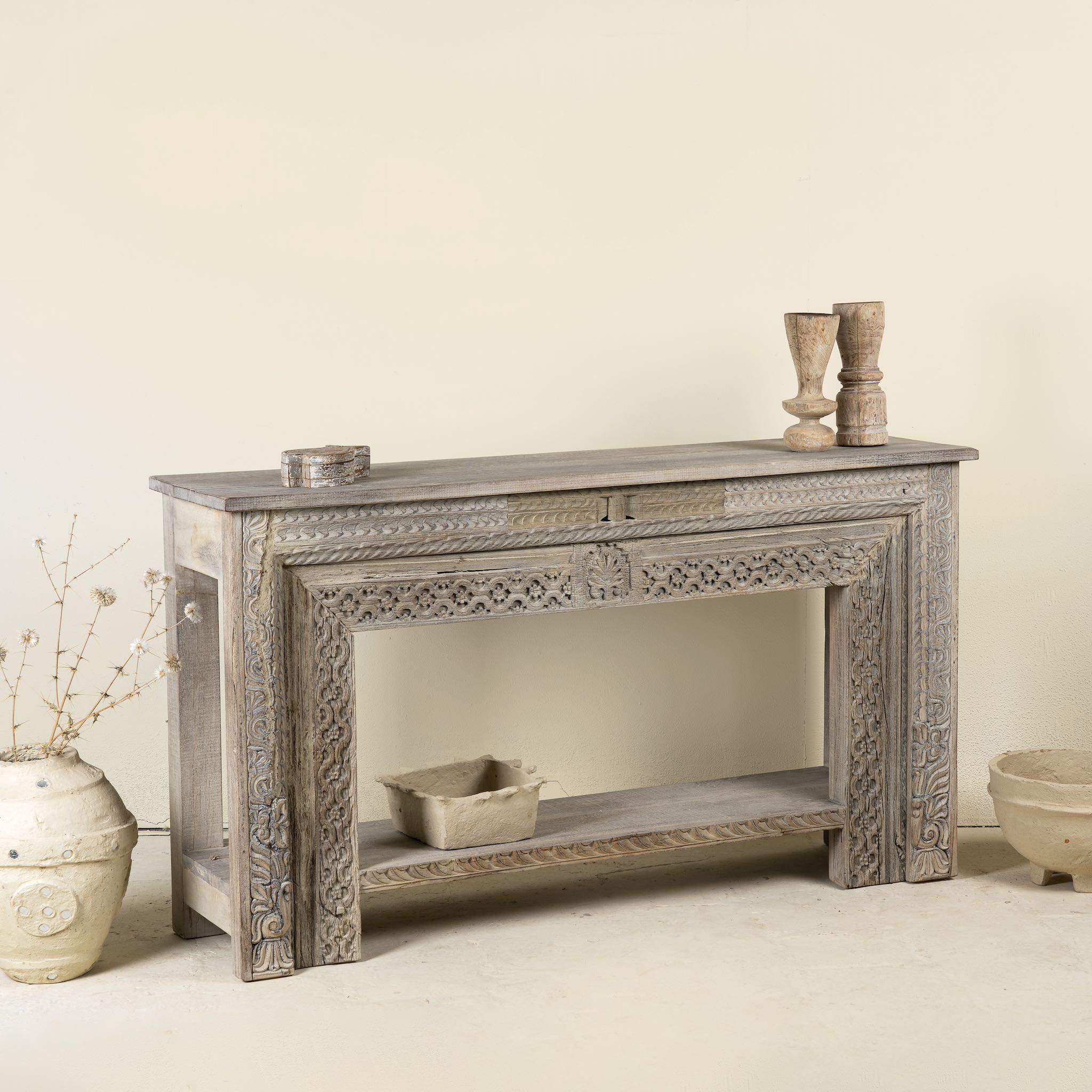 Side angle image of a hand-carved console table made from reclaimed teak wood, featuring intricate traditional Indian carvings and natural aged finish.
