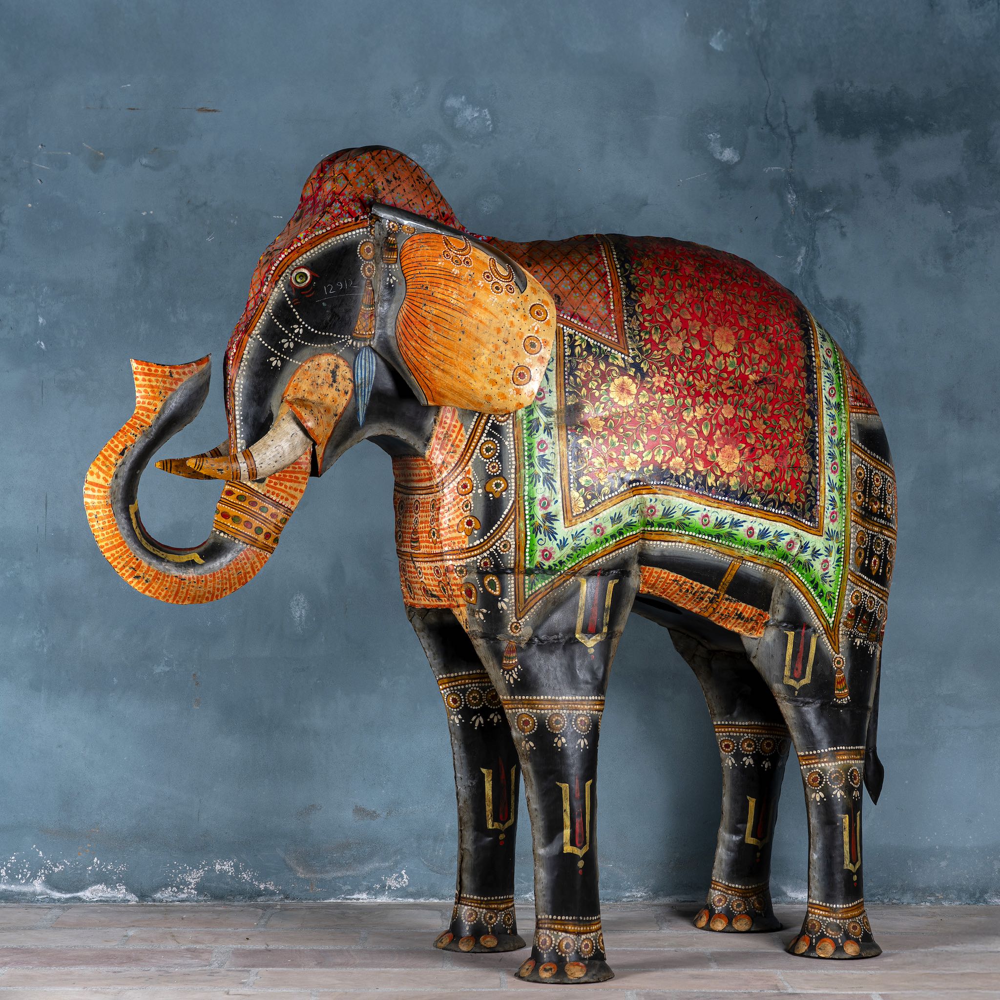 Large hand-painted decorative elephant sculpture made of sheet metal in vibrant Rajasthani style, featuring intricate floral and geometric patterns in red, green, and gold. Ideal for enhancing entrance areas, restaurant lobbies, hotel receptions, or luxury interior spaces.