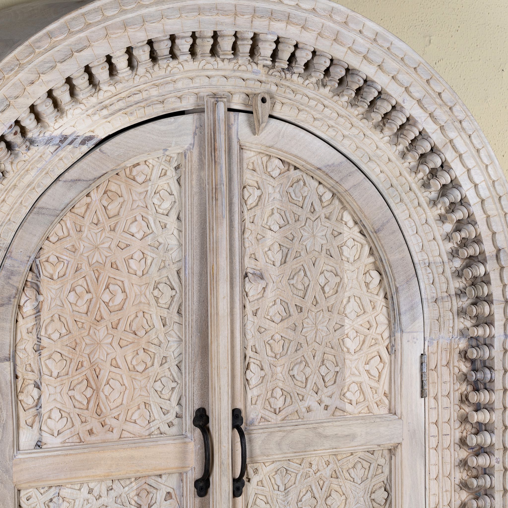 Close up picture of Ashwin wardrobe with arched carved doors, a unique furniture design from our mango wood furniture collection.