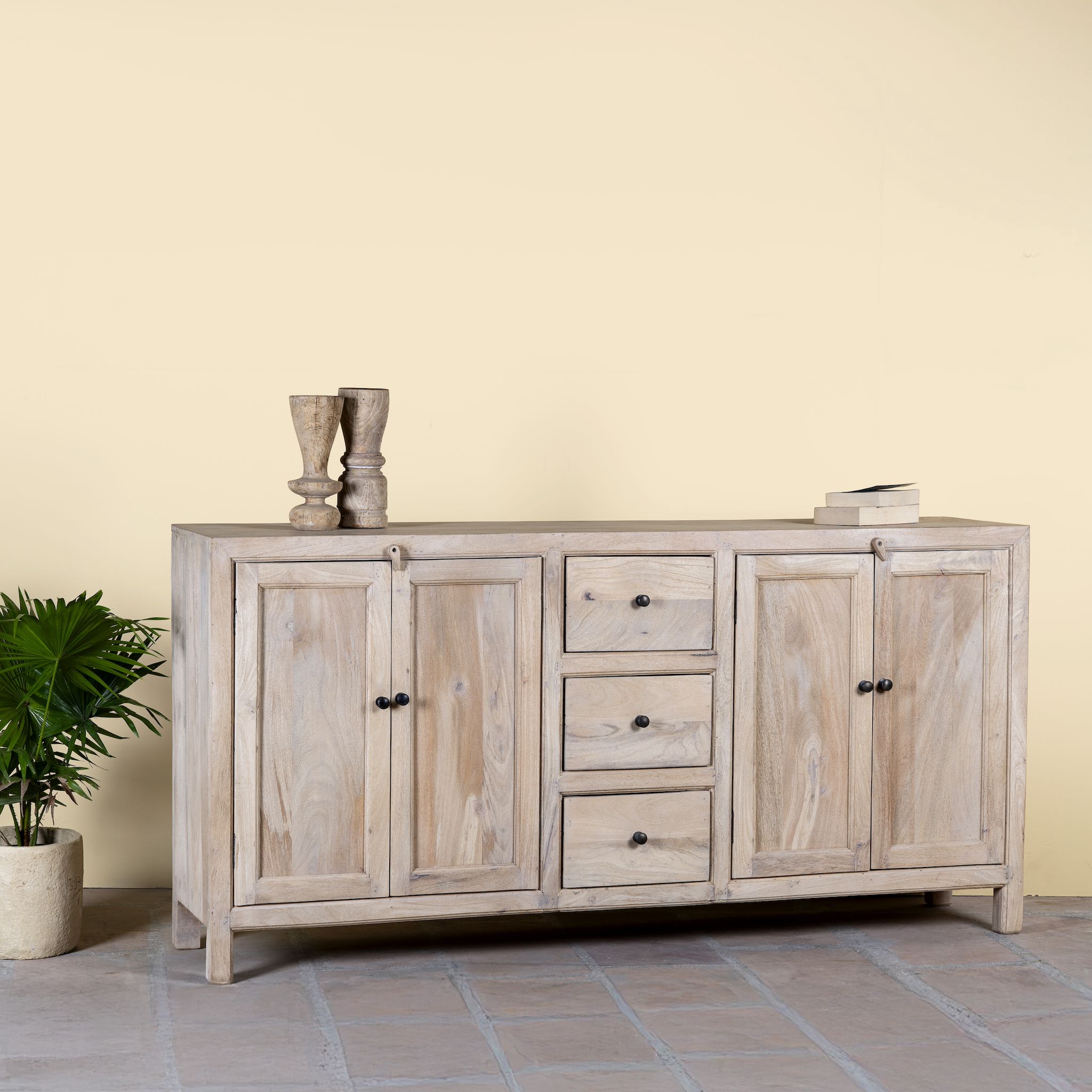 Side angle image of a sandblasted wood sideboard with drawers and cabinets, living room furniture in relaxed Ibiza style.