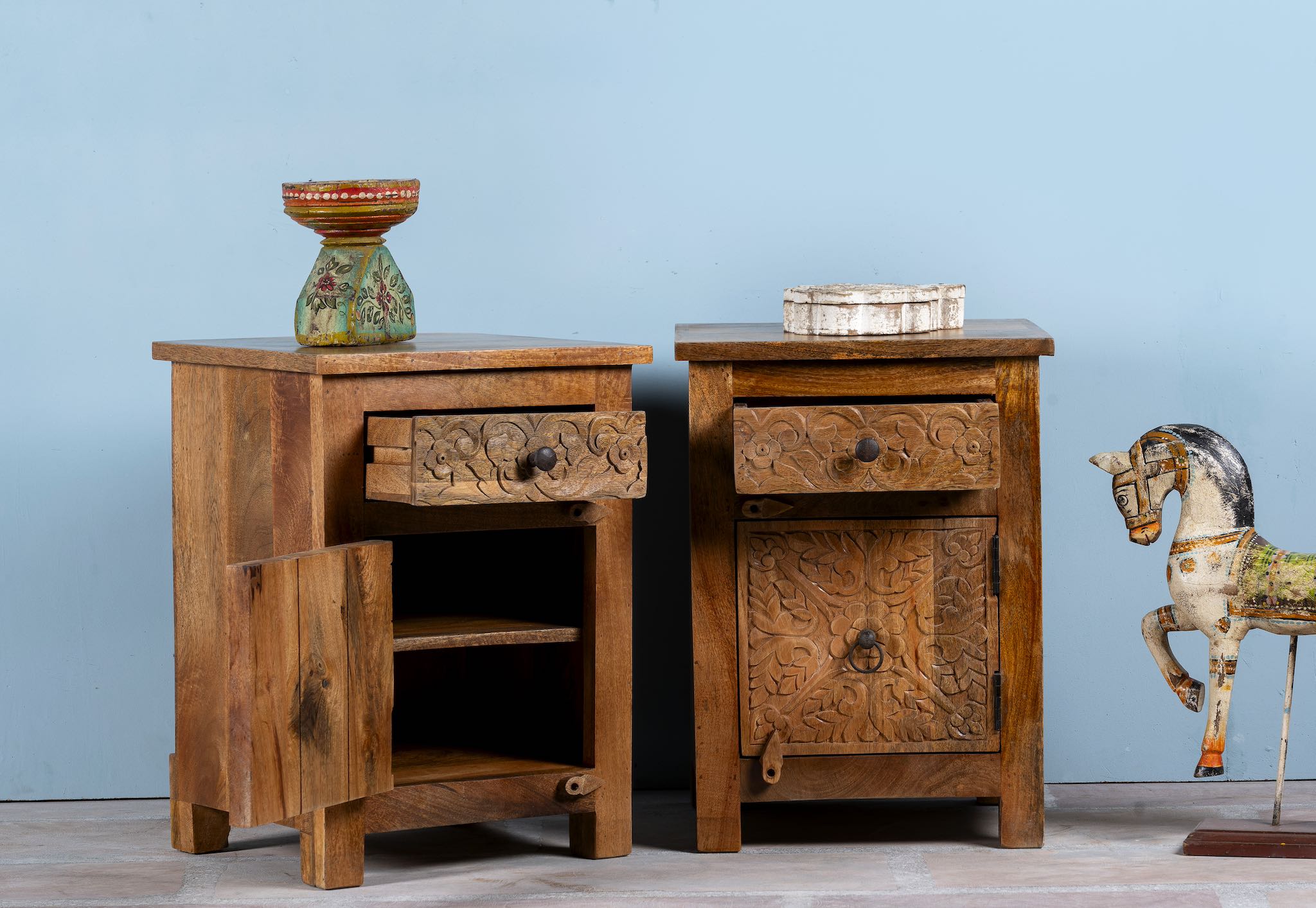Open drawer image of a pair of mango wood night stands with floral hand carvings in natural wood colour.