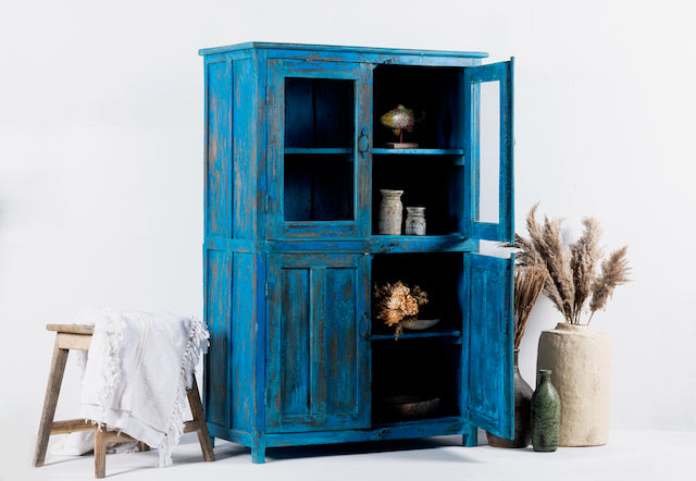 Side angle image of a refurbished blue teak wood showcase with glass and wooden doors – sustainable dining room furniture crafted from reclaimed teak with vintage flair.