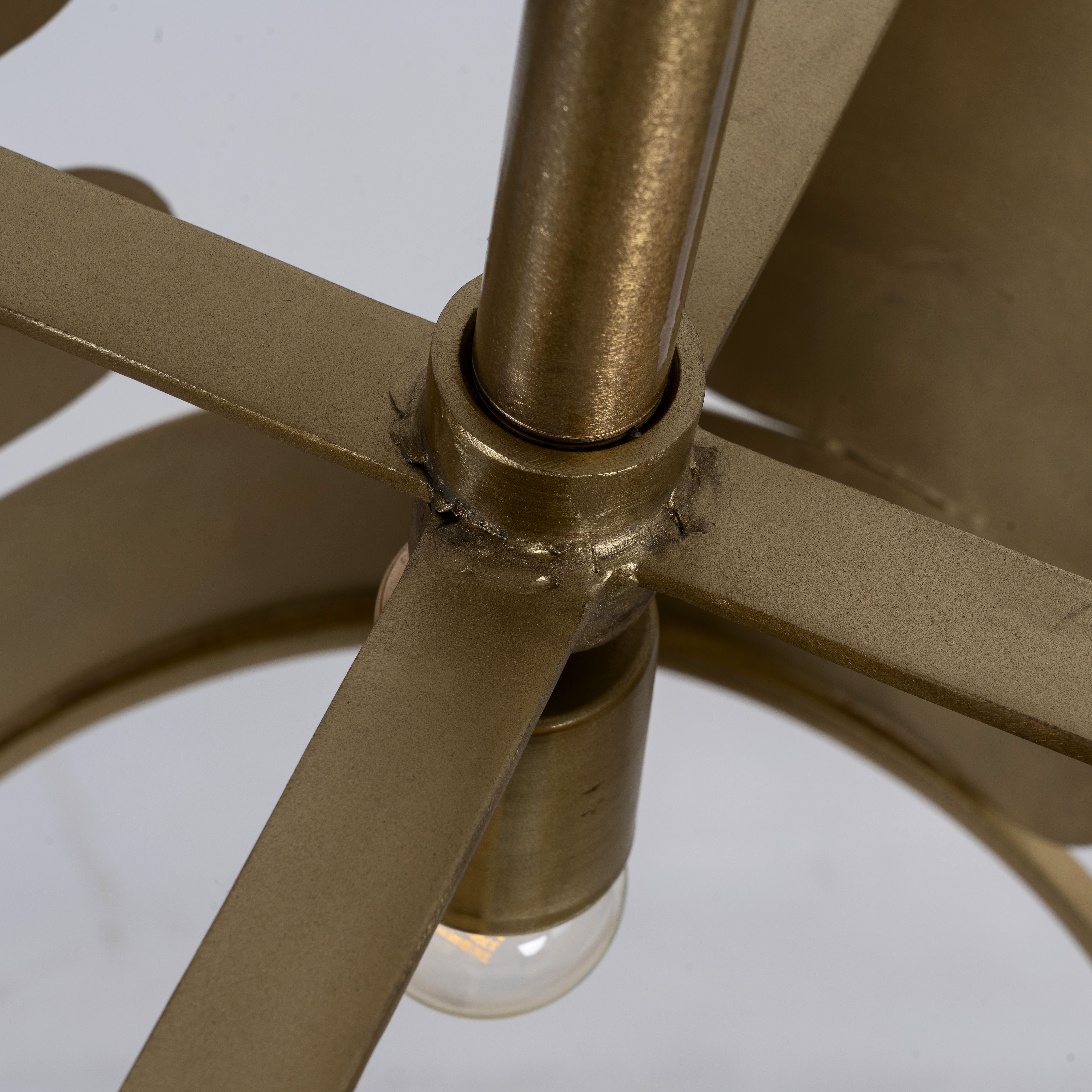 Close up image of a medium round brass-plated metal pendant lamp with geometric cutout design – a modern take on vintage lights perfect for dining rooms, kitchens, or stylish living areas.