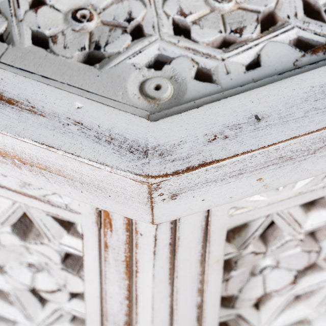 Close up image of a square mango wood coffee table with floral carvings and white wash finish; hand-carved and rustic, 90 × 90 × 46 cm.