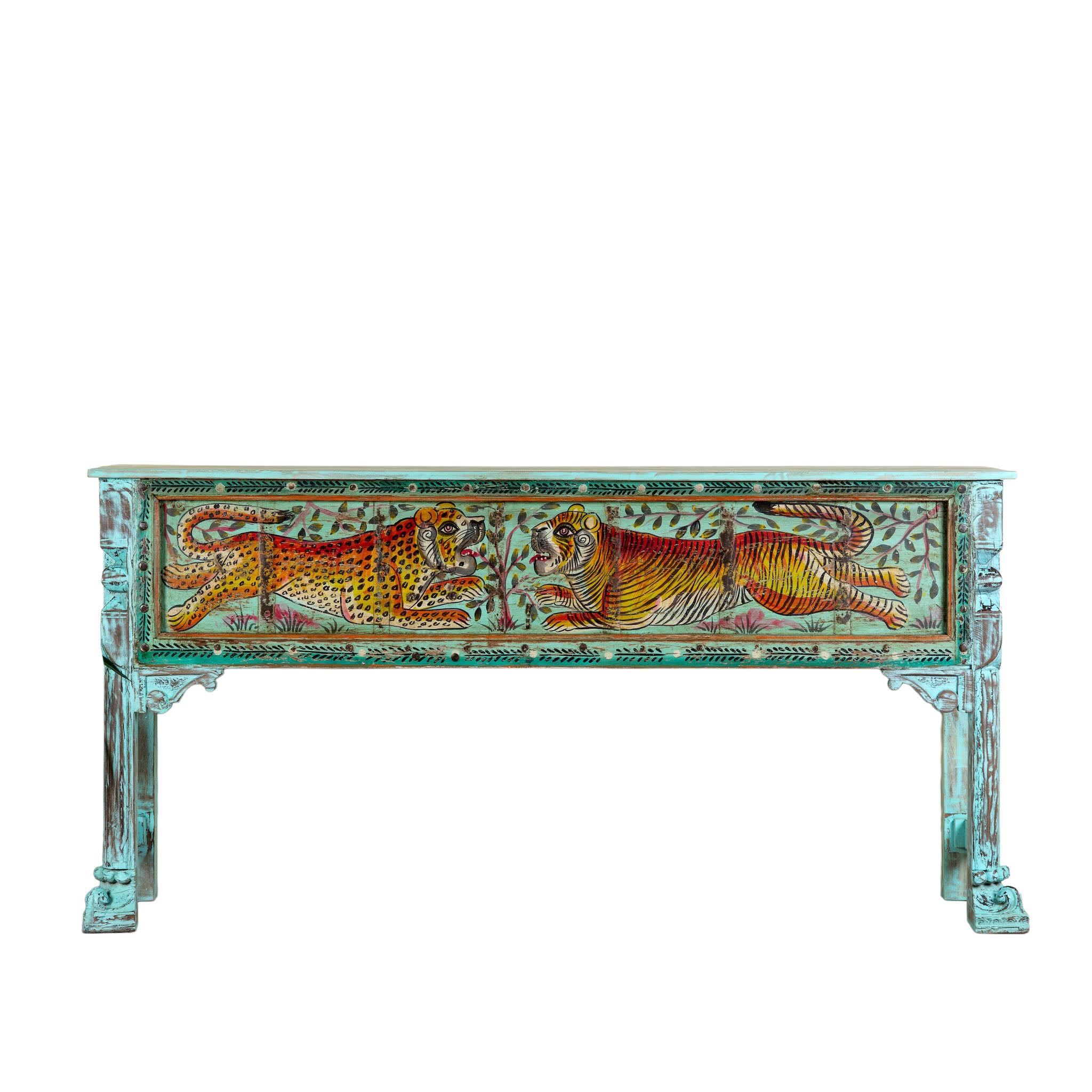 White background image of a hand-painted reclaimed wood console table Bunsee with tiger and leopard motifs in turquoise vintage finish. A unique piece of furniture for bohemian interiors and artistic spaces.