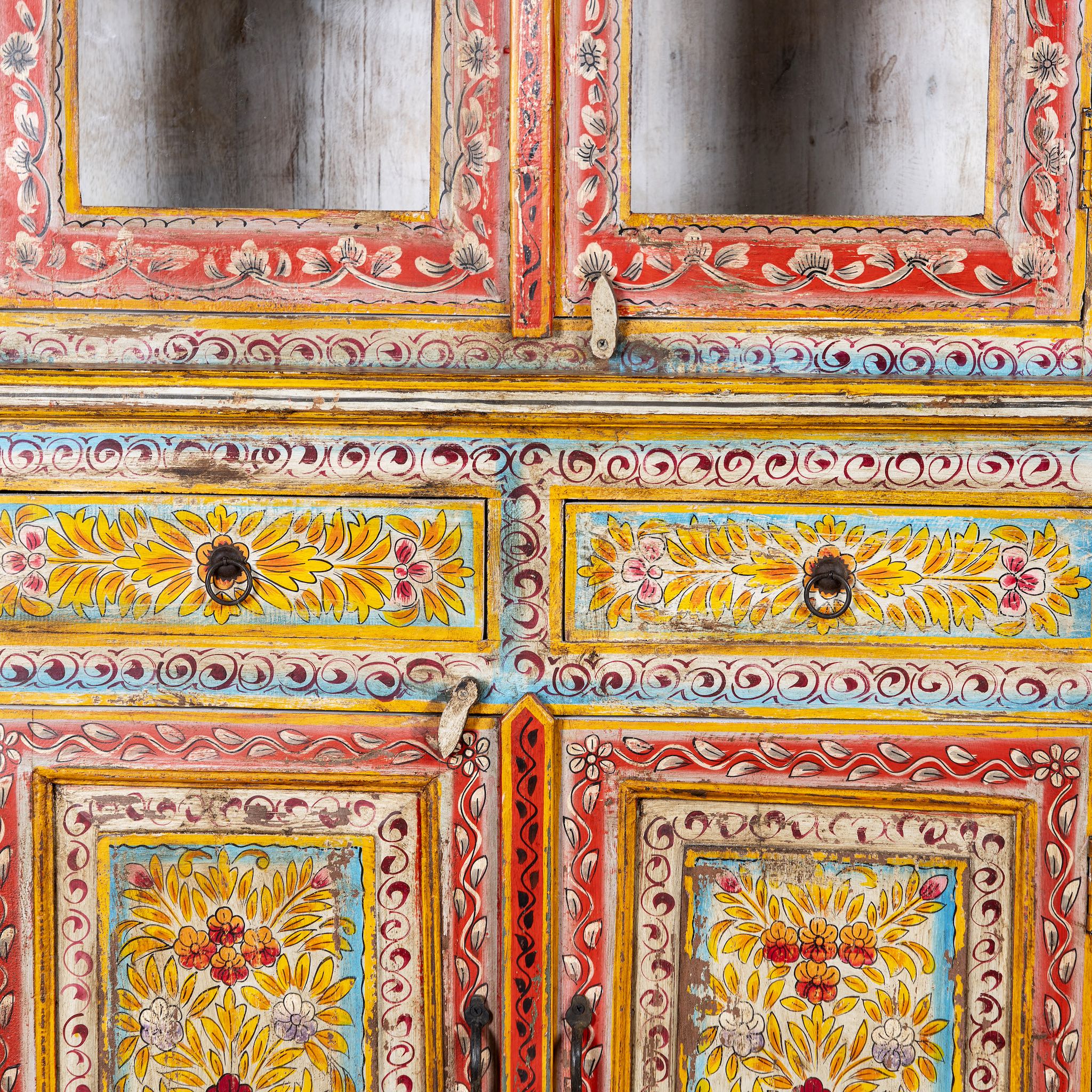 Close up image of a hand-painted two-part showcase made of reclaimed wood with floral motifs; unique furniture for a boho chic living room, 94 × 48 × 203 cm.