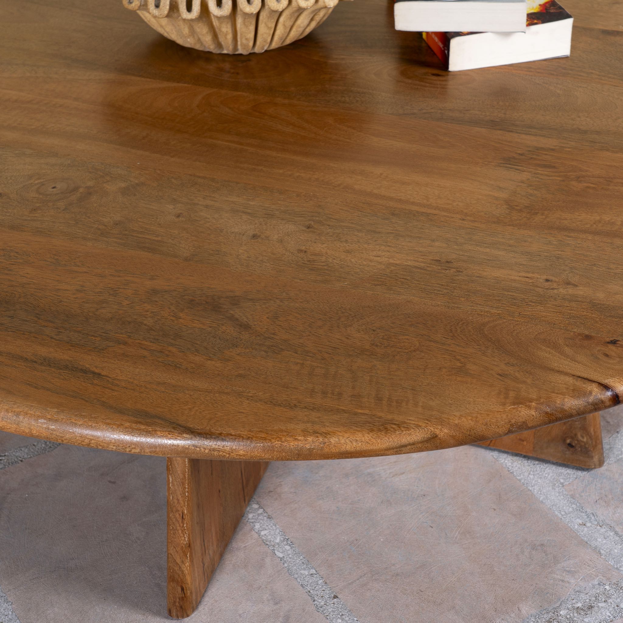 Close up image of a round mango wood coffee table with rustic finish and cross-base design, Dia 120 × H 45 cm, living room furniture.