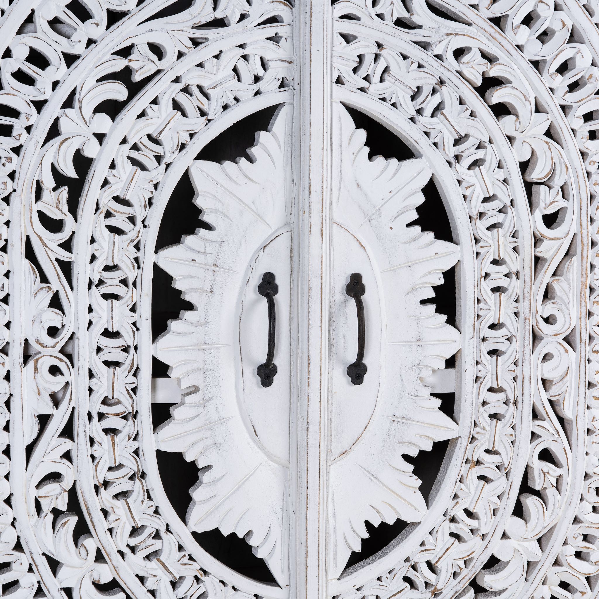 Close up image of a Hand-carved mango wood wardrobe with floral and geometric patterns and white-washed finish – carved wooden furniture for boho chic and Mediterranean-inspired interiors.