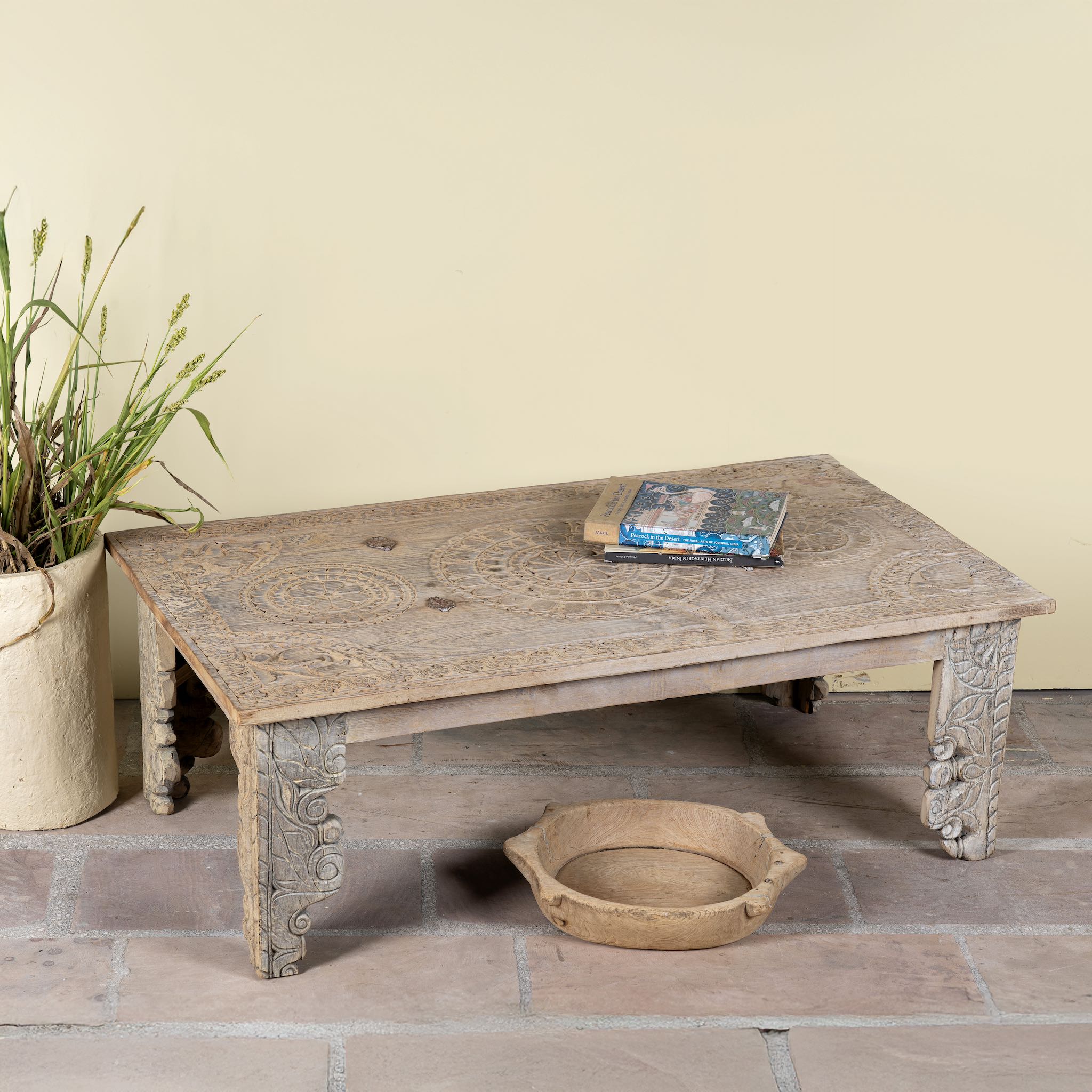 Side angle image of a sandblasted reclaimed teak wood coffee table with carved antique Indian door top; unique teak wood furniture and living room furniture, 140 × 40 × 48 cm.