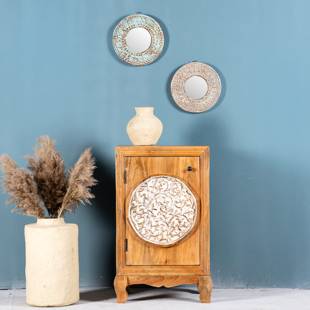 Whitewashed mango wood nightstand with hand-carved floral door – a handcrafted example of carved wooden furniture ideal for rustic and vintage bedrooms.
