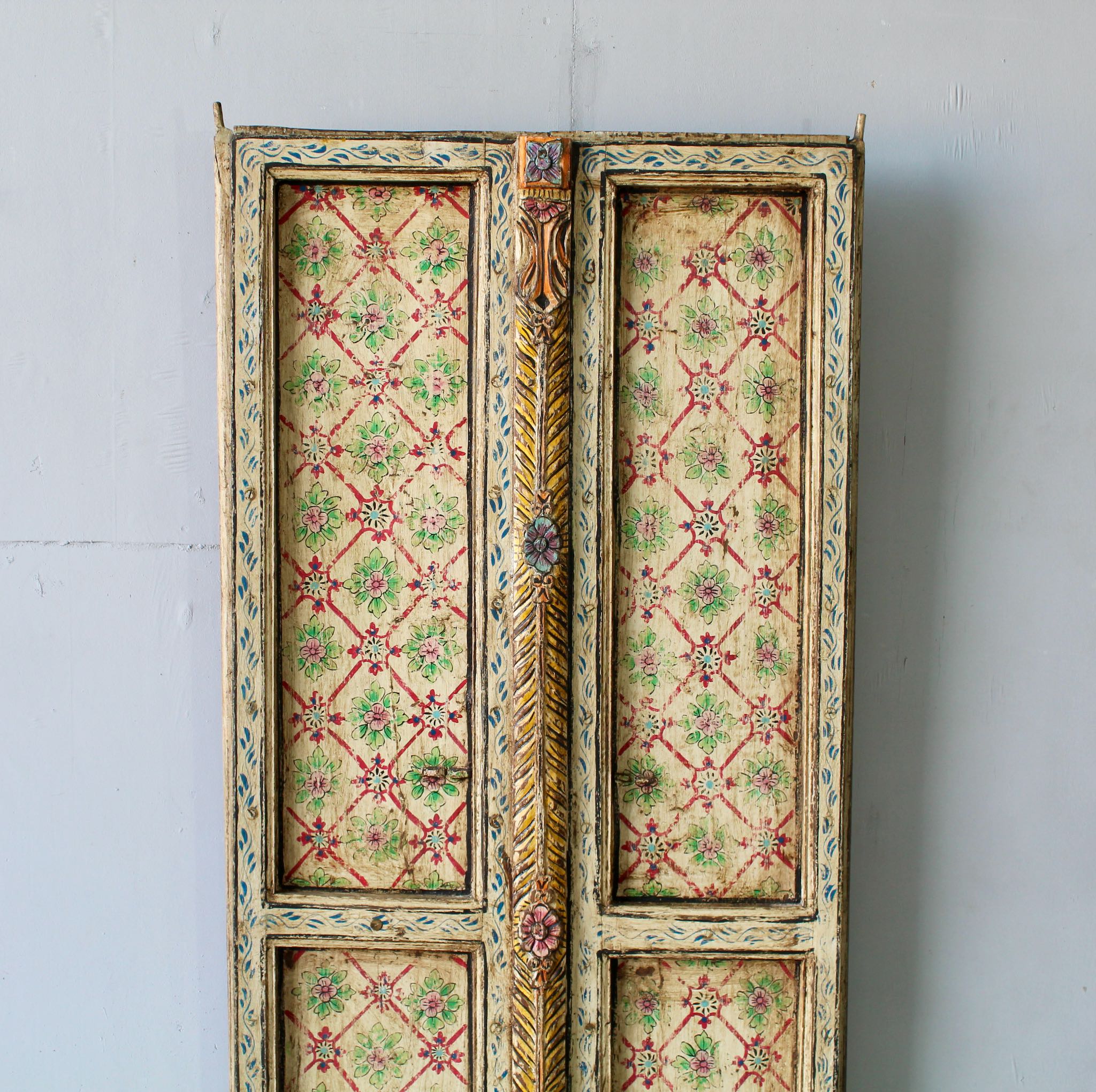 Close up image of an antique Indian teak wood door panel with hand-painted floral lattice design, vintage wall panels for heritage and vintage home decor.