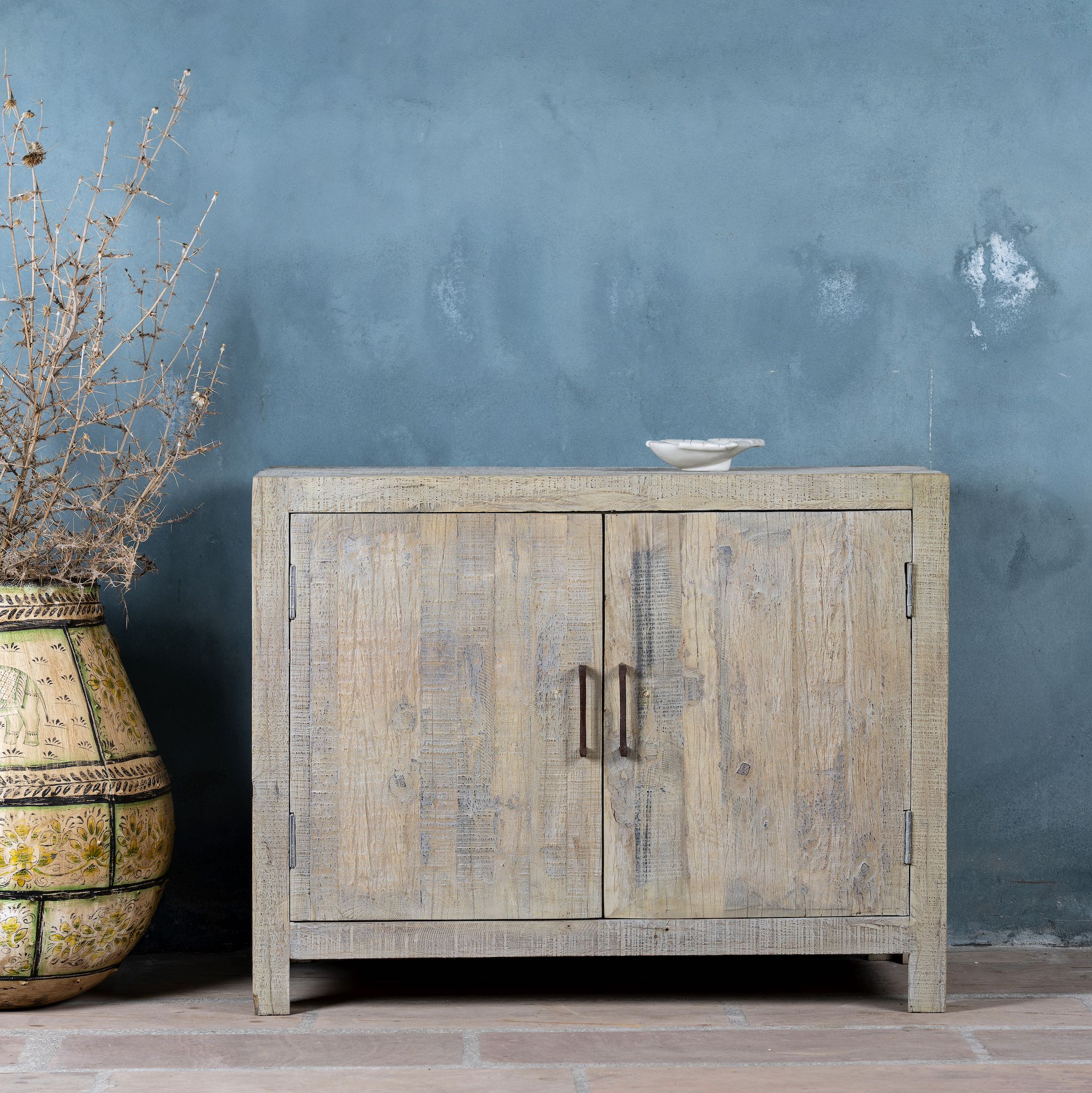 Lifestyle image of a Ibiza style bathroom cupboard made of reclaimed wood with sandblasted finish and two doors, 100 × 50 × 80 cm.