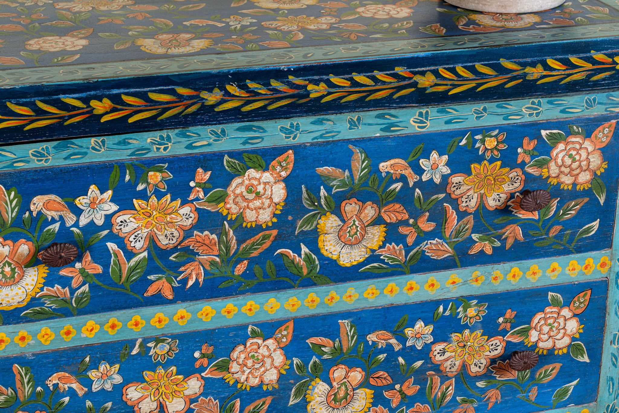 Close up image of a hand-painted cupboard made of reclaimed wood with floral drawer fronts – Divisha model by Om Home & Garden