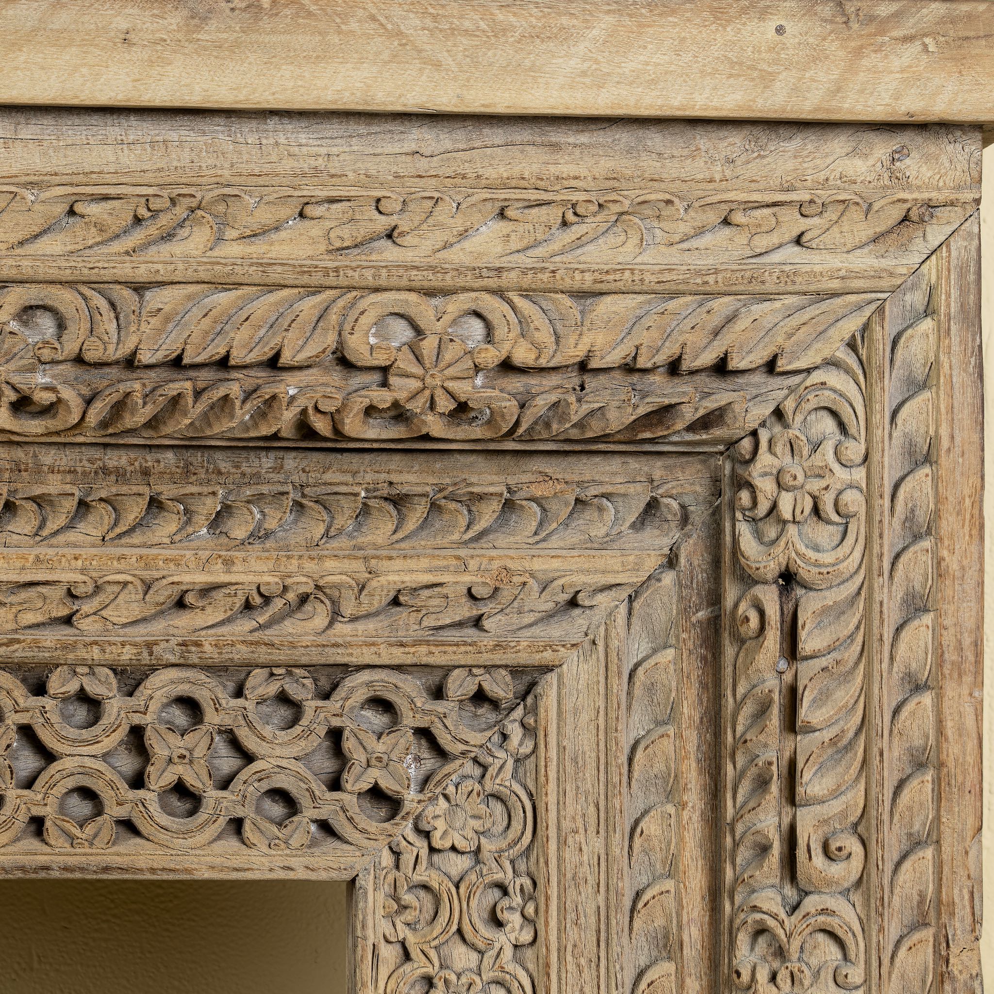 Close up image of a ornate console table crafted from reclaimed teak wood and refurbished architectural elements, featuring intricate hand-carved detailing with floral and geometric motifs, showcasing a vintage artisanal aesthetic.