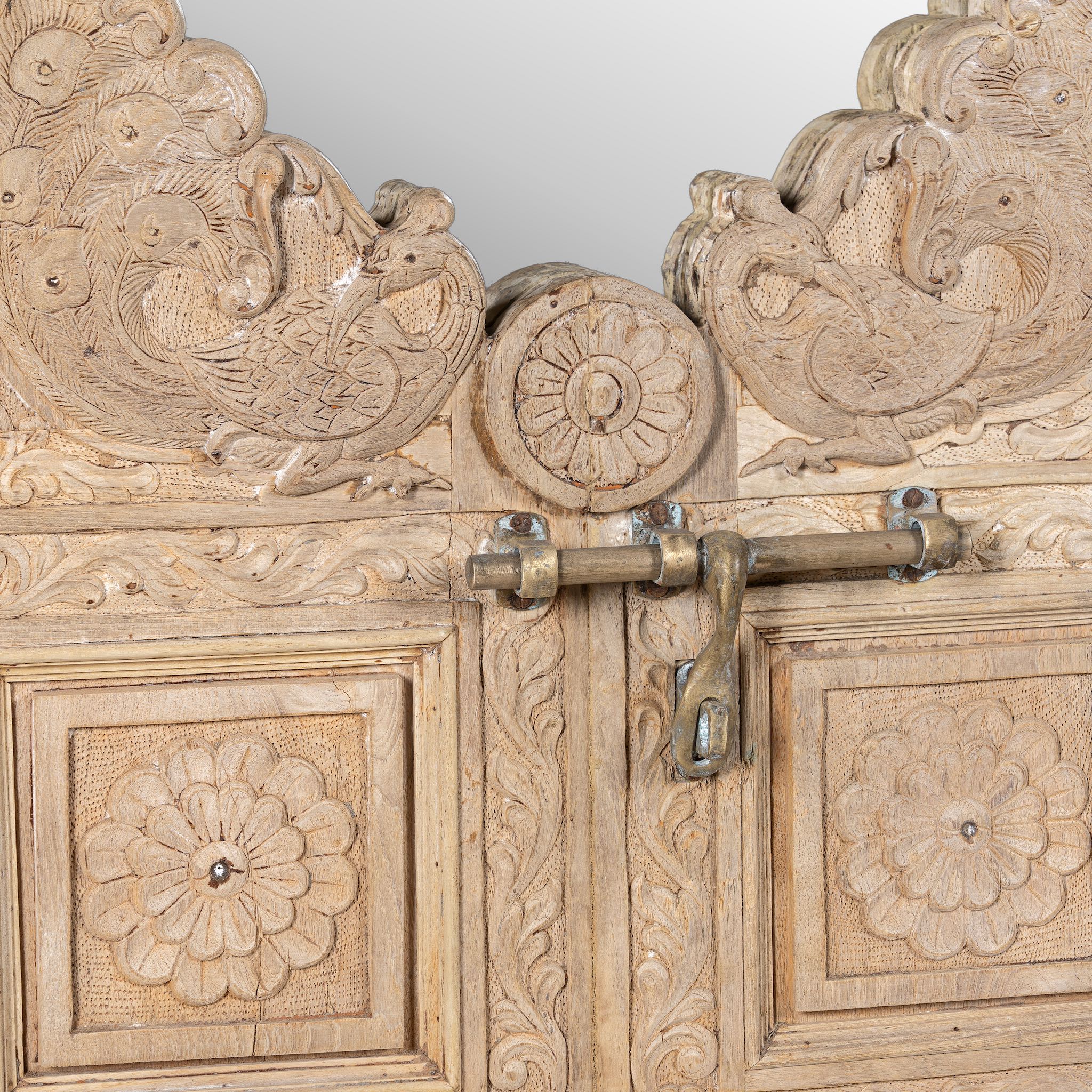 Close up image of a handcarved teak wood mirror made from an antique Indian window frame with brass lock; unique wooden furniture, 60 × 70 cm.