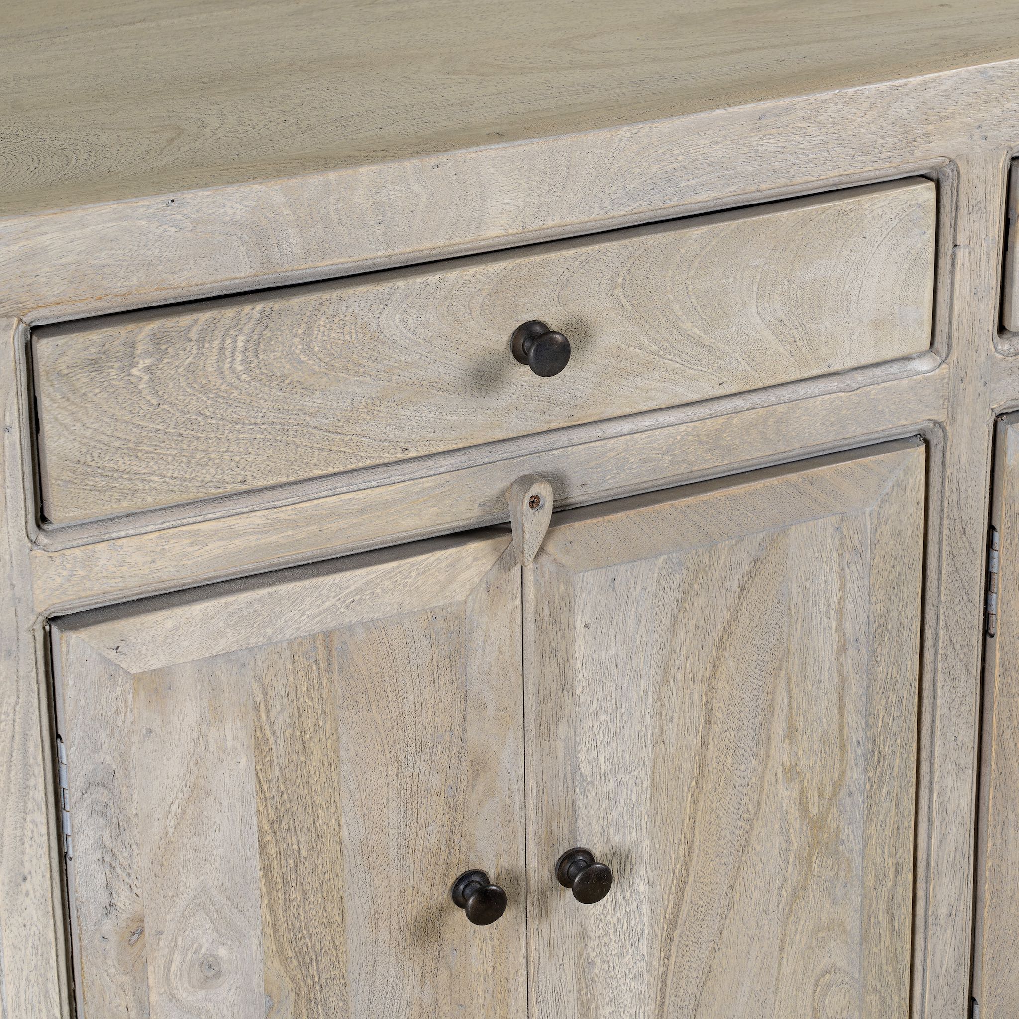Close up image of a sandblasted mango wood sideboard with 3 drawers and 4 cabinet doors; Mediterranean-inspired mango wood furniture, 180 × 40 × 90 cm.