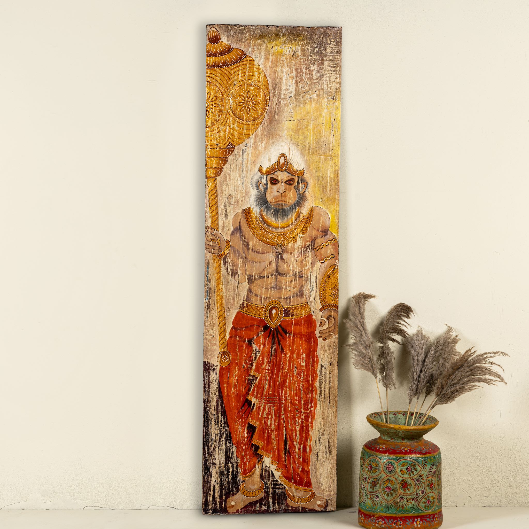 Hand-painted vintage door panel measuring 54x3x195 cm, depicting the powerful figure of Lord Hanuman holding a golden mace, adorned in traditional attire with intricate jewellry, set against a distressed wooden background for an aged, sacred appearance.
