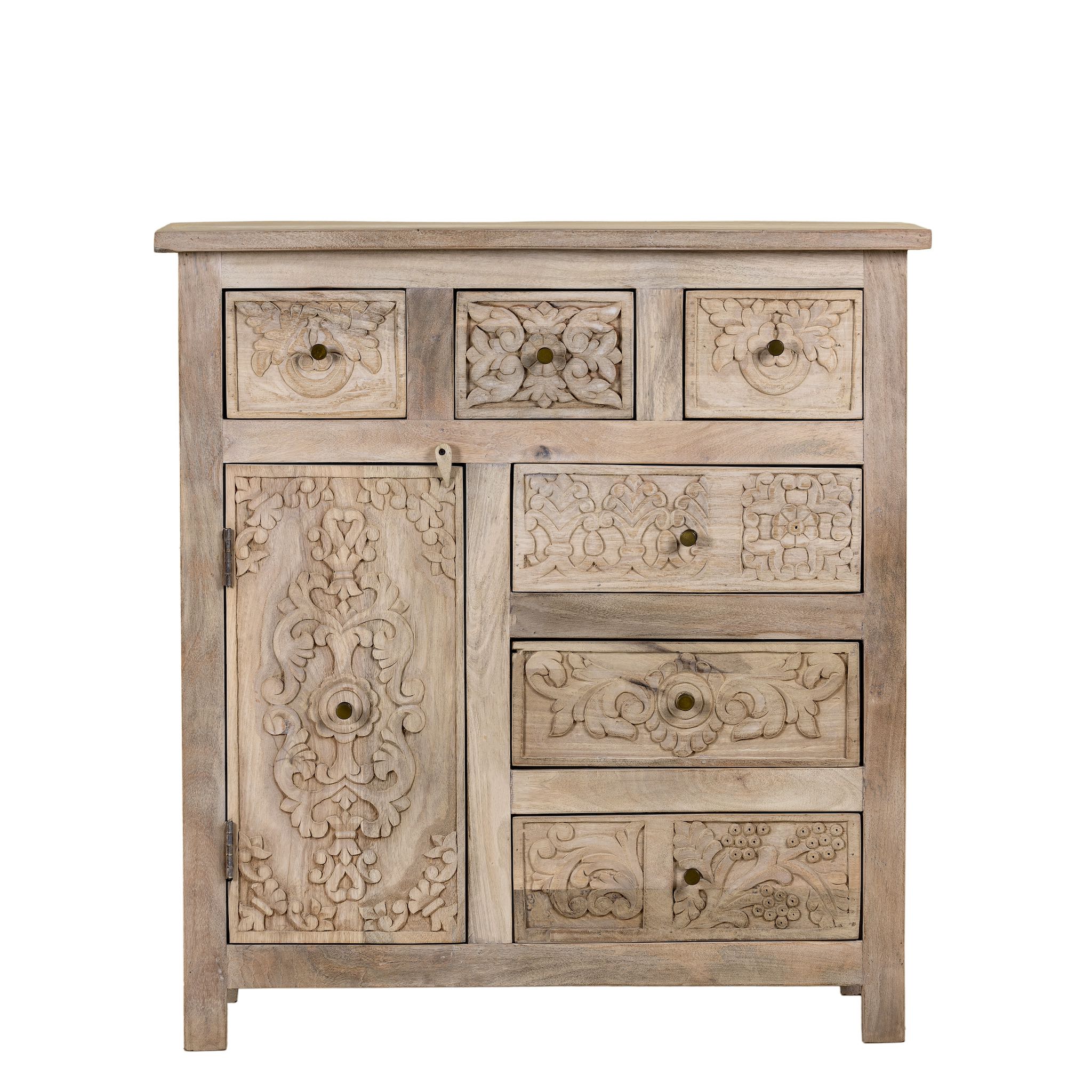 White background view of a hand carved mango wood cupboard with 6 drawers and 1 door, iron fitted door knobs and floral carvings.