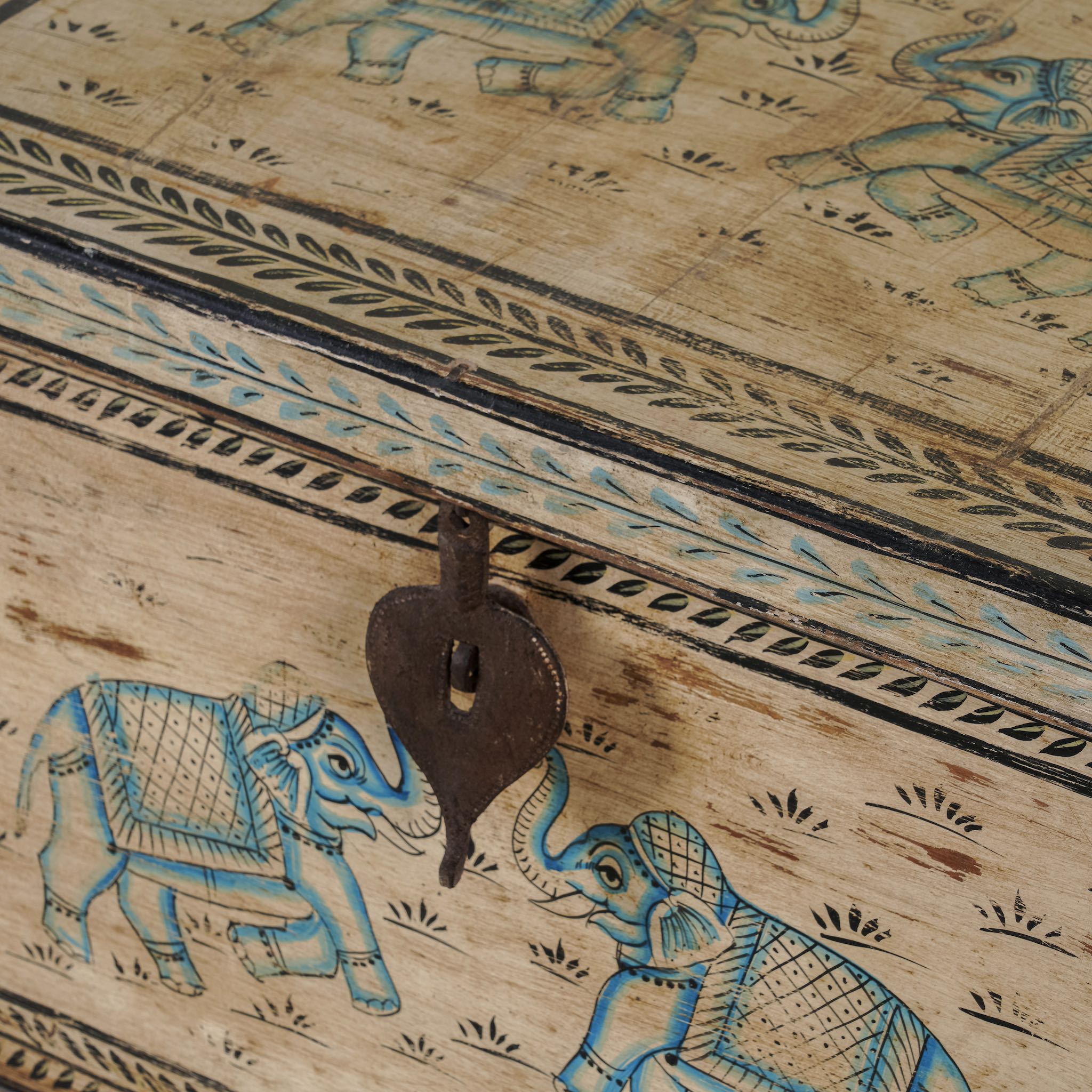 Close up image of a large hand-painted reclaimed teak wood chest with iron accents – teak wood chest and reclaimed wood furniture with bohemian artistic detail.
