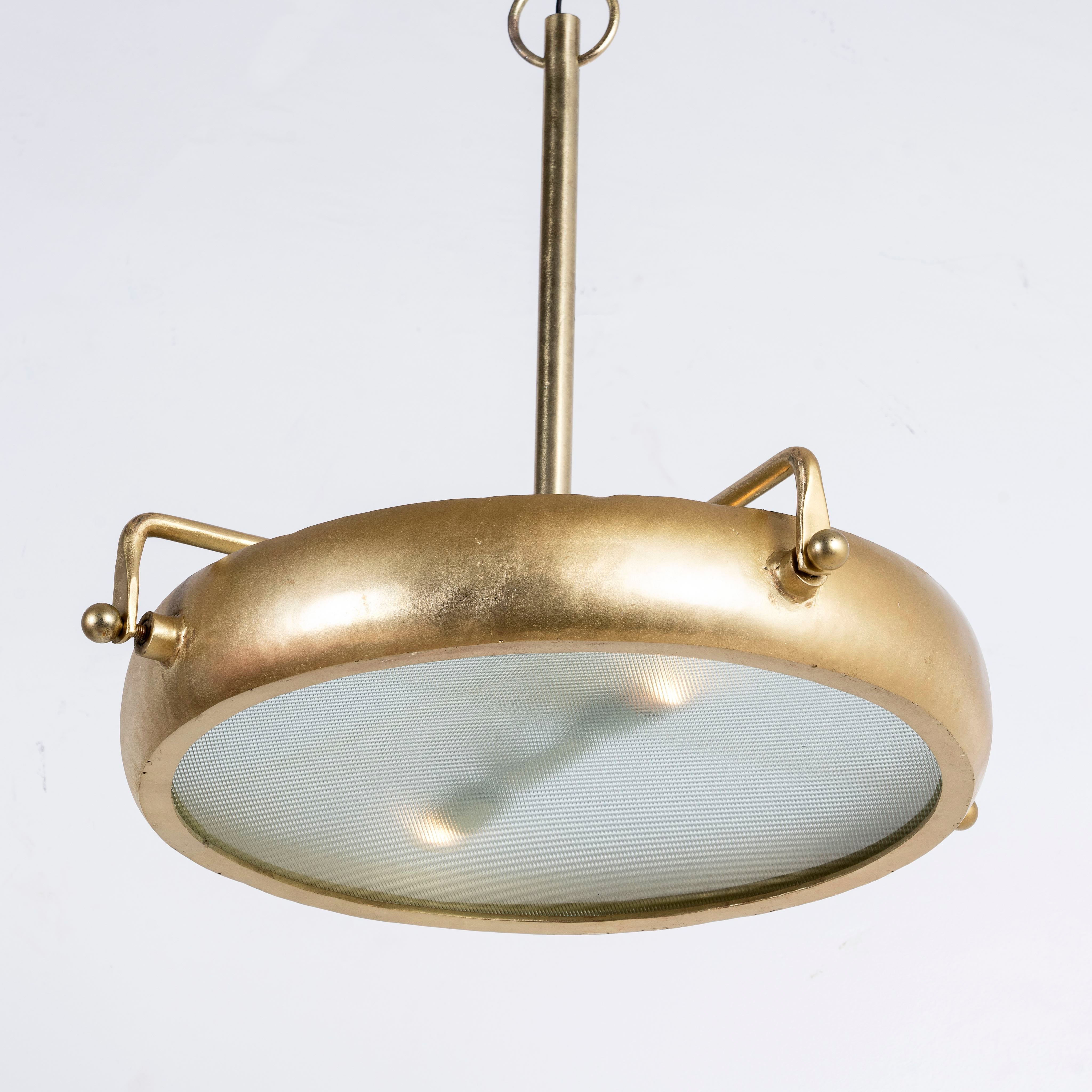 Side angle image of a large round pendant lamp with clear hand-blown glass and brass-plated iron frame – retro lighting and artsy lamp ideal for kitchens, living rooms, or dining areas.