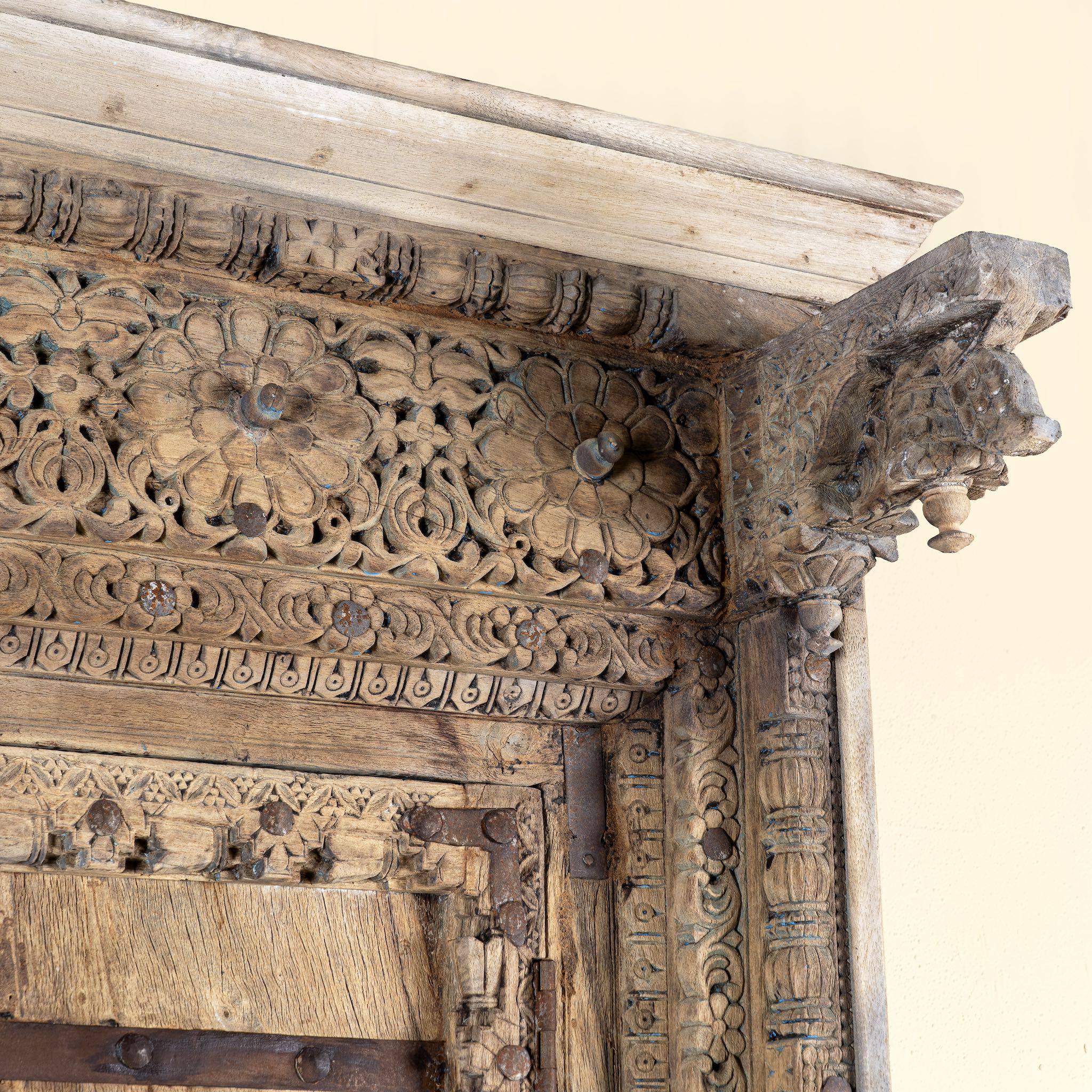 Close up image of a cabinet with antique carved teak door, part of our teak wood furniture collection, perfect for a bohemian interior.