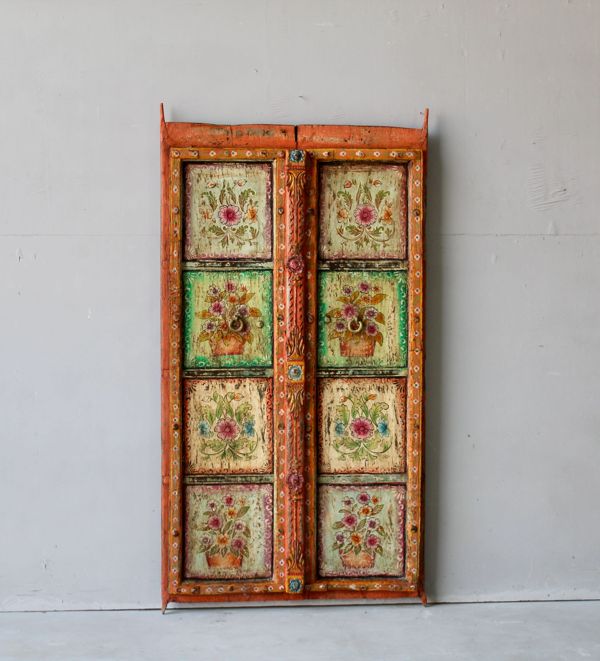 Hand-painted antique teak wood Indian door with floral motifs, rustic orange frame, reclaimed wood vintage wall panels for bohemian and vintage home decor.