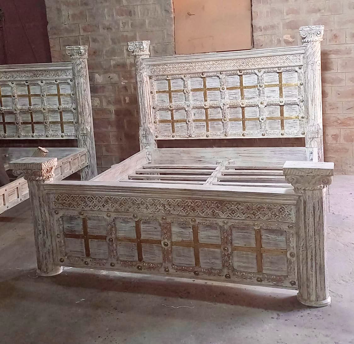 Wooden bed with intricate carvings in a rustic setting. Reclaimed wood bed frame with messing applications, 180cm by 200cm
