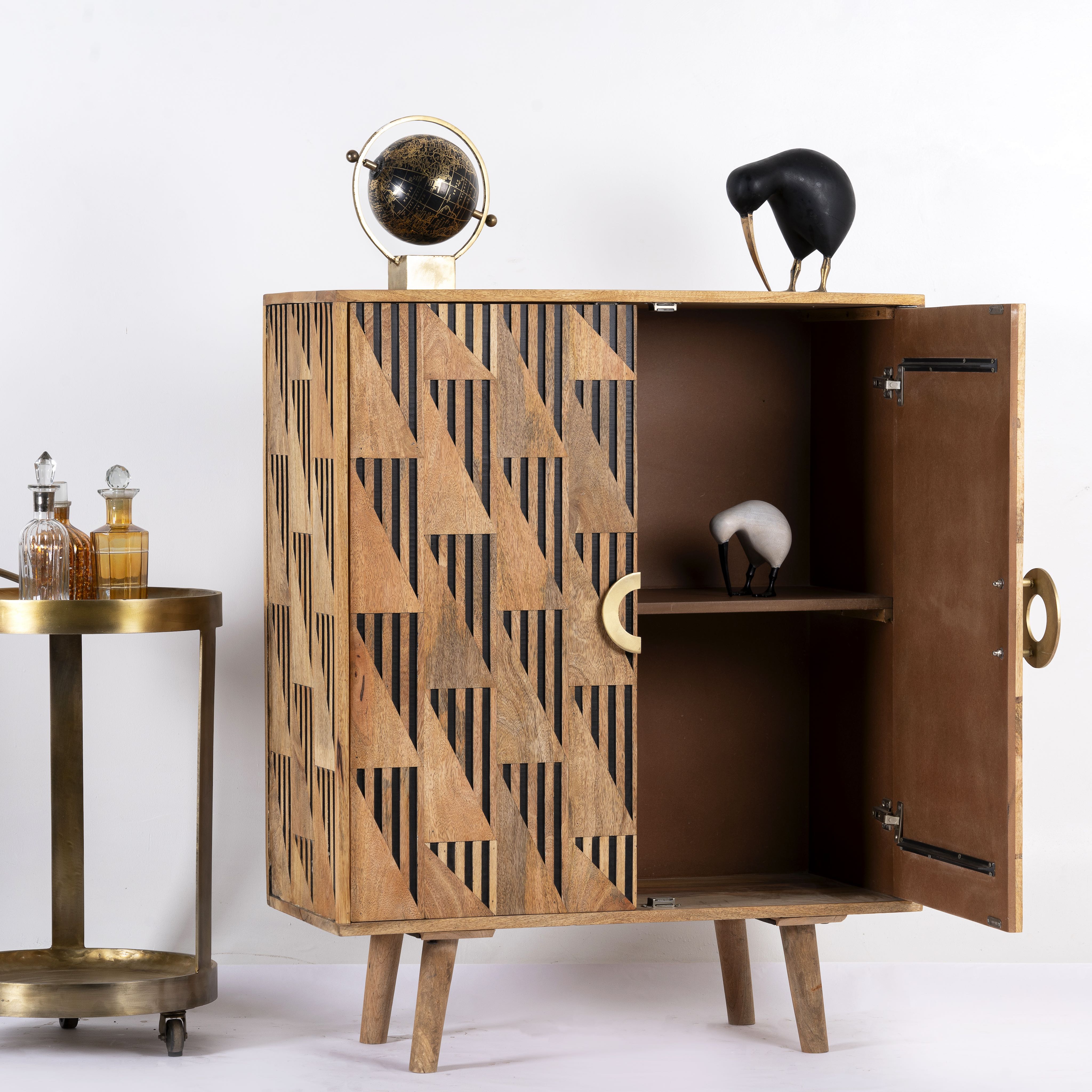 side angle image of a artisanal mango wood cabinet with natural doors, black frame, and brass knobs, 91 × 113 × 41 cm.