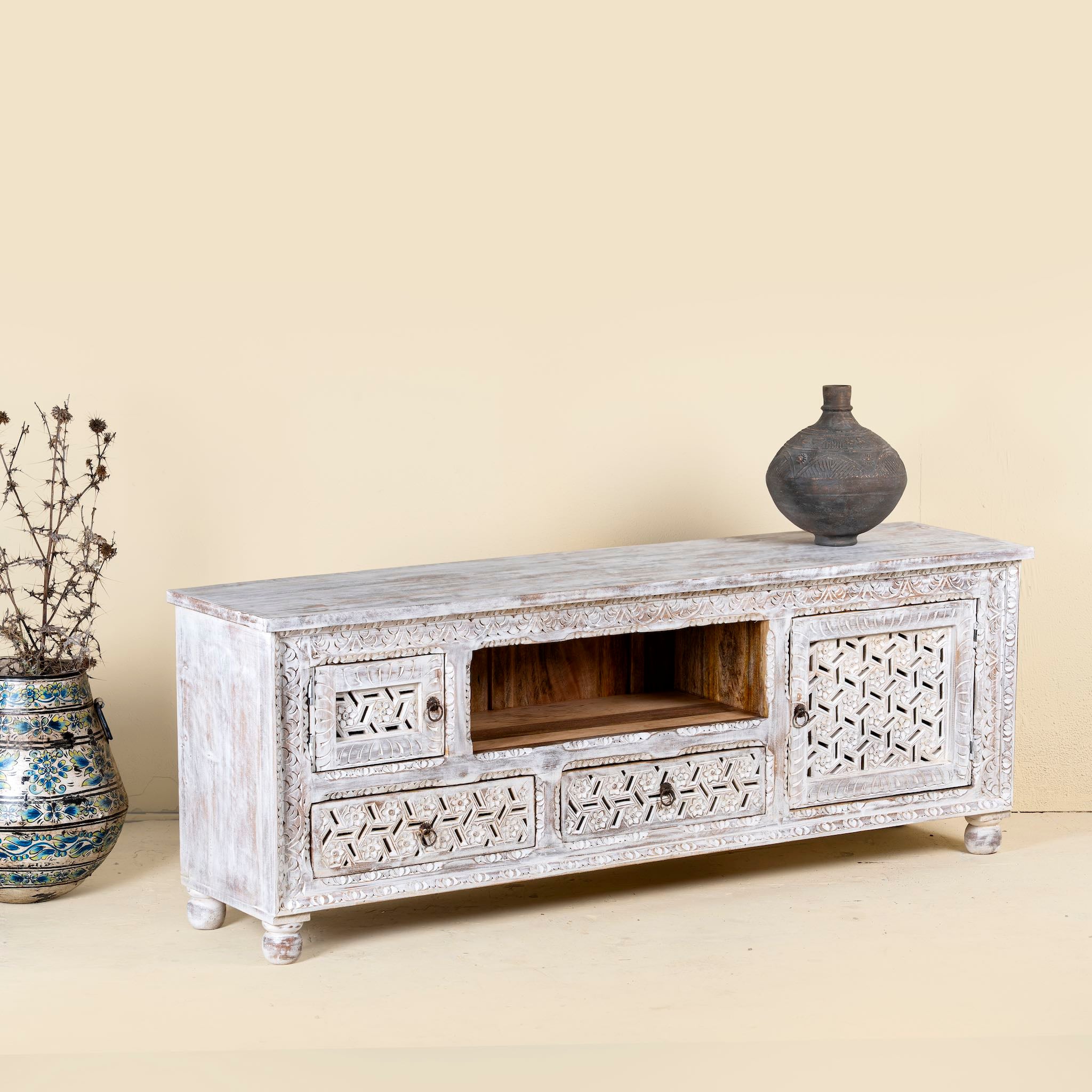 Side angle image of a hand-carved mango wood TV unit Pari in Mediterranean style, versatile living room furniture with drawers and compartments, 170 × 60 × 37 cm.