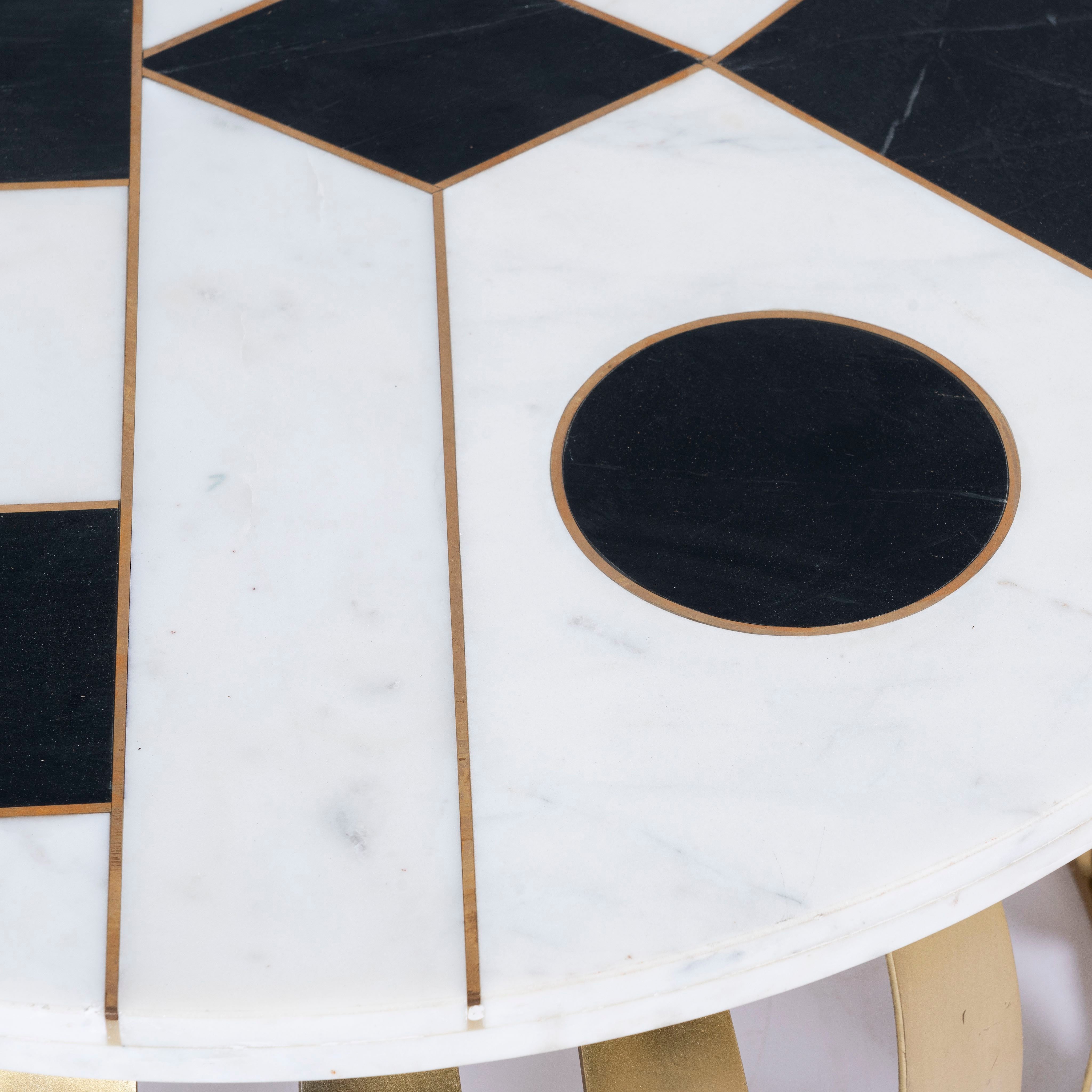 Close up image of a round industrial style coffee table with hand-forged metal base and checkered marble top; also functions as a metal bar table, 82 cm diameter, 45 cm height.
