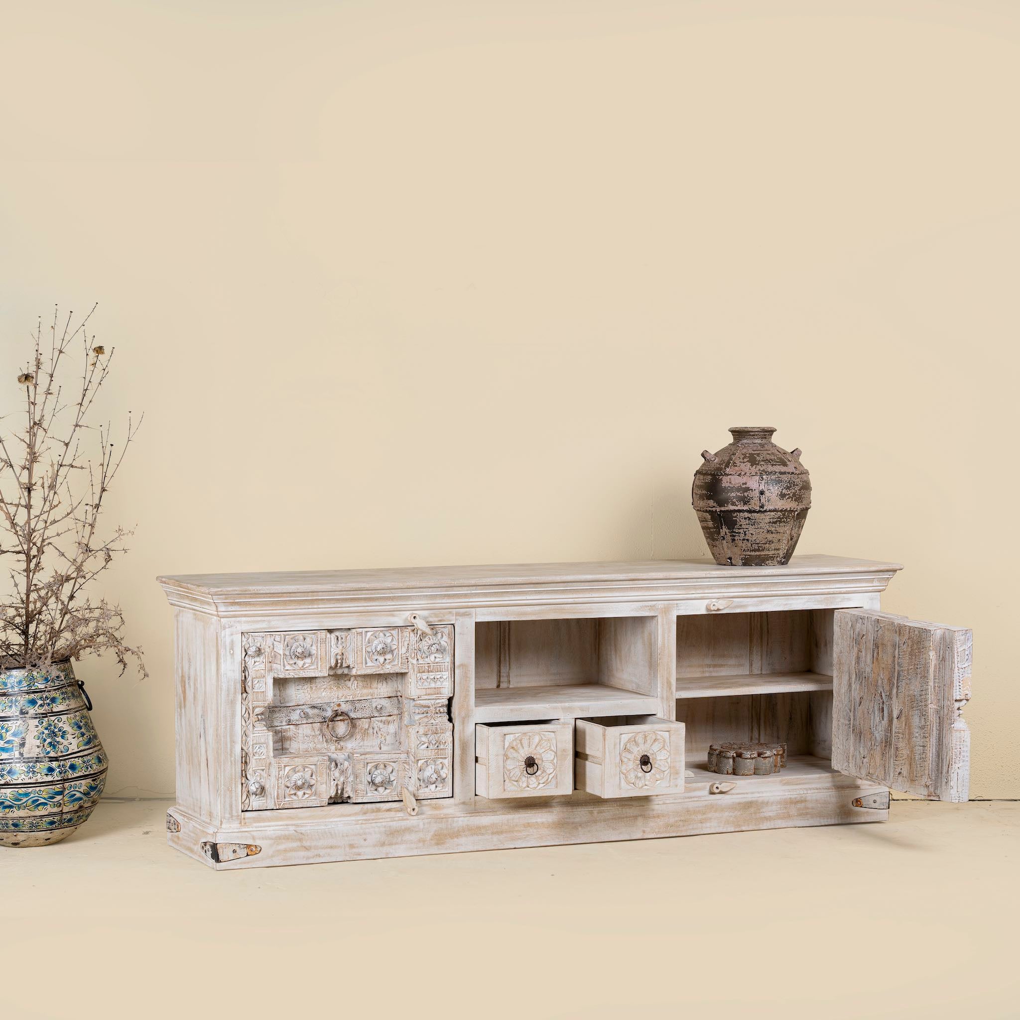 Open drawer and door image of a old door cabinet with hand-carved antique teak panels, whitewashed mango wood body, drawers and shelf, 180 × 40 × 70 cm.