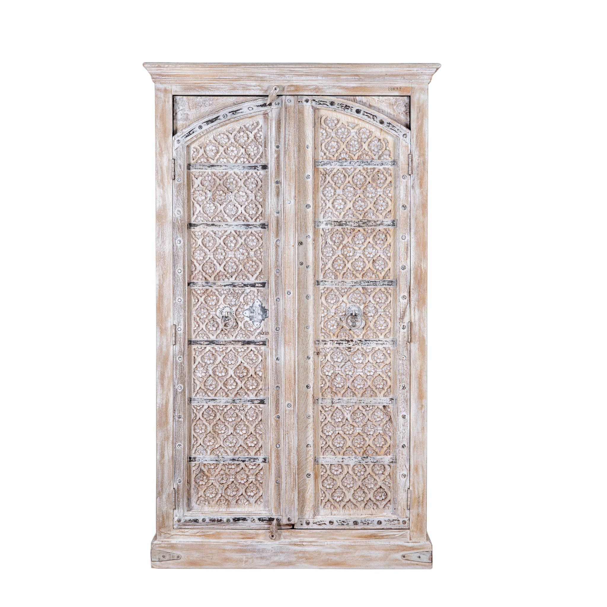 White background picture of a handcrafted carved wood wardrobe with whitewashed finish and arched teak doors – Ruchi by Om Home & Garden, vintage-inspired white washed furniture with artisanal detailing.
