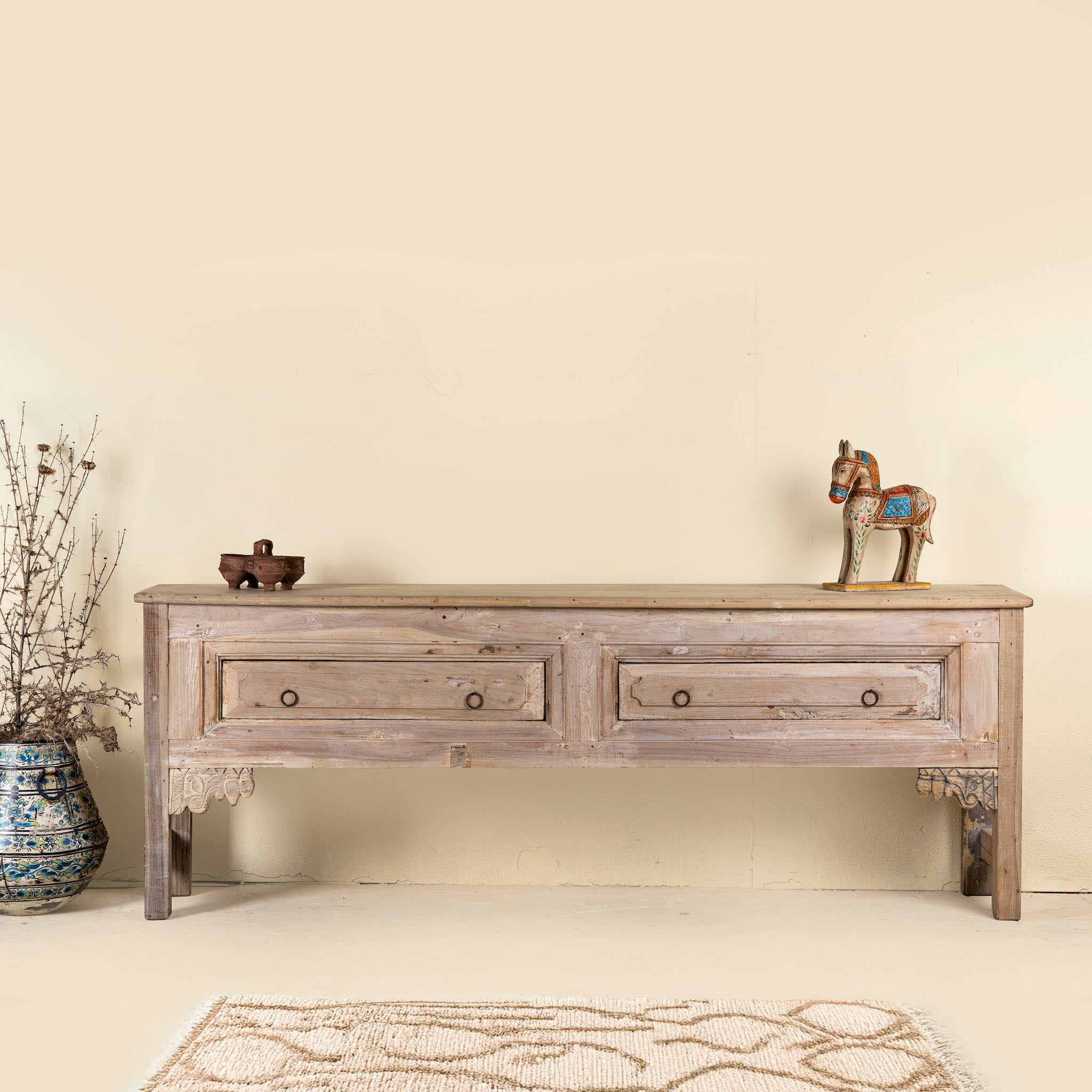 Teak wood console table with two drawers, carved leg details, and sanded reclaimed finish, 223 × 45 × 83 cm.