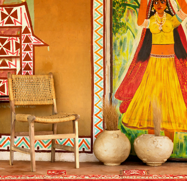 Lifestyle image of a handcrafted Ibiza style wooden chair made from recycled teak with upholstered seat and natural weed canopy, 45 × 50 × 47 cm, backrest height 85 cm.