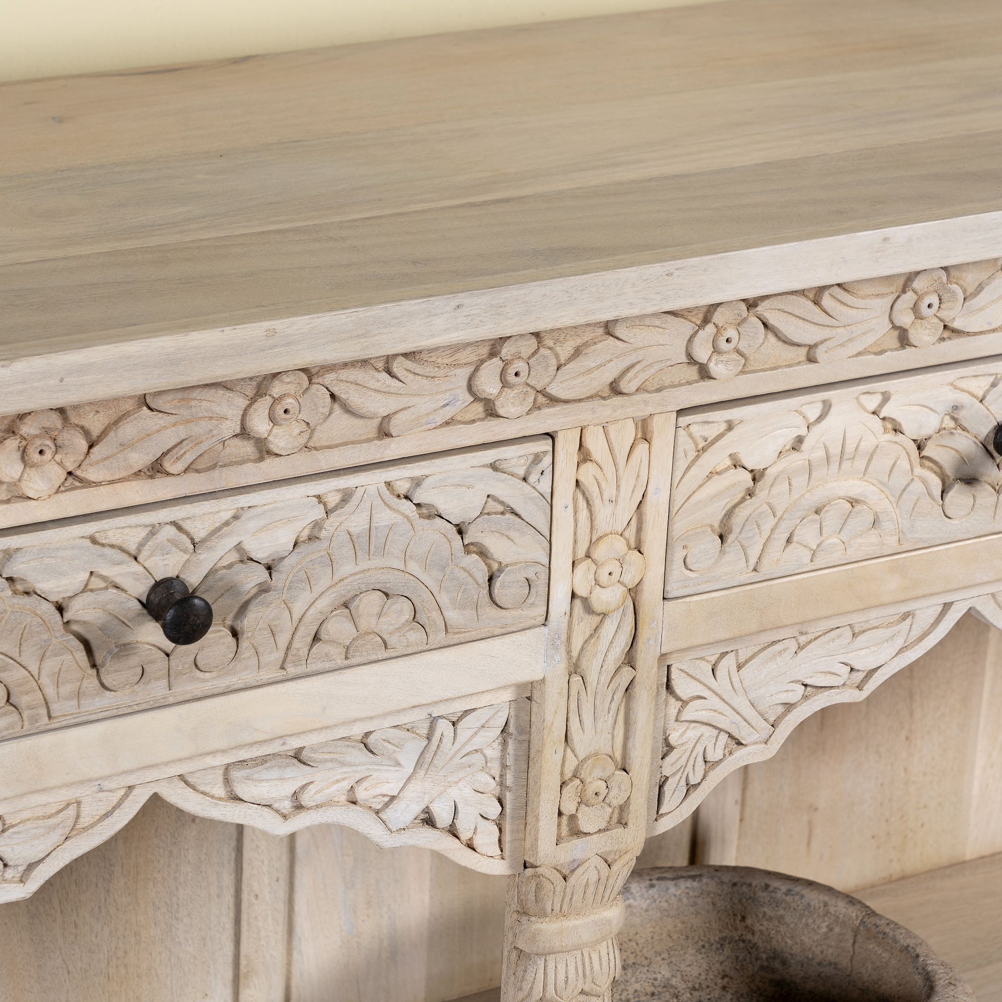 Close up image of a carved console table made of sandblasted mango wood with four drawers and hand-carved front; vintage entryway table, 200 × 40 × 71 cm.