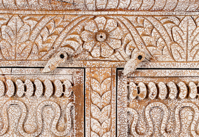 Close up image of a hand-carved mango wood sideboard with a three-layer vintage finish, featuring two doors and three drawers—perfect for rustic or bohemian interiors.