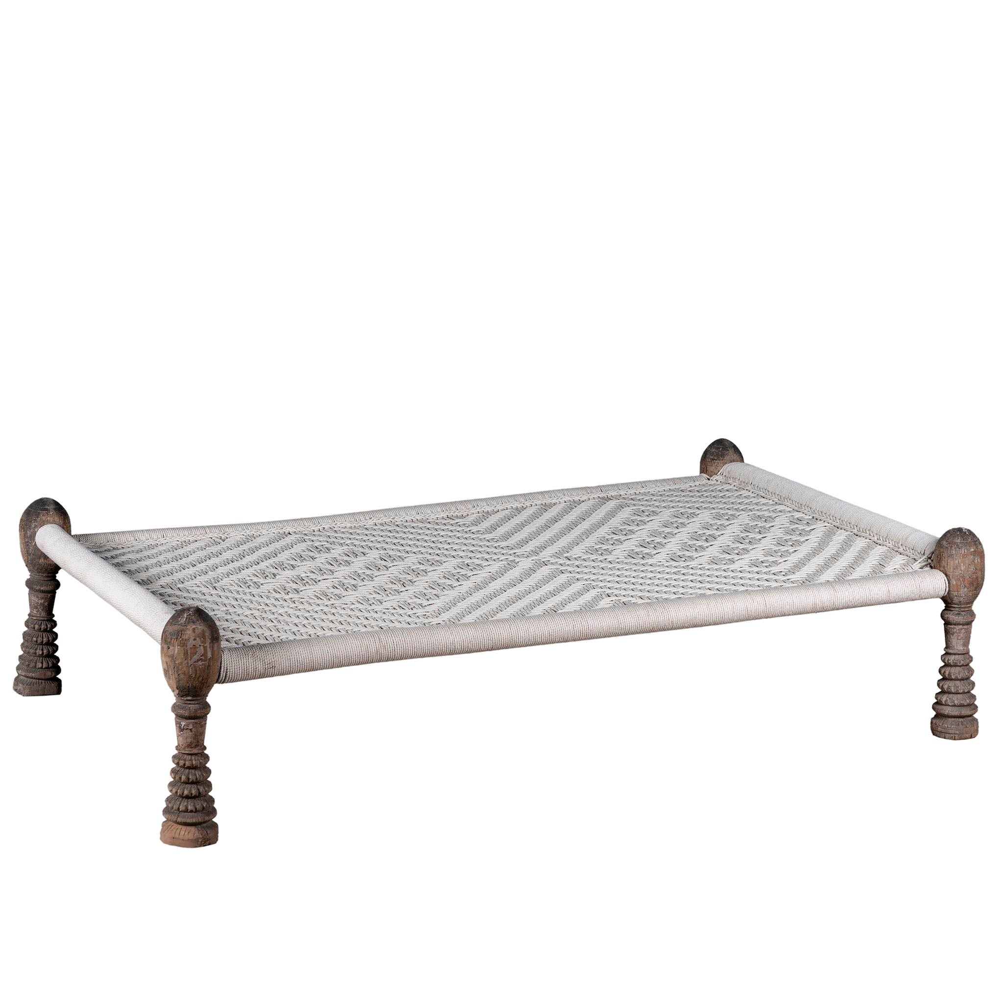White background image of a handwoven Indian Charpai bed with reclaimed teak frame and carved legs; perfect for Indian home decor, 170 × 105 × 45 cm.