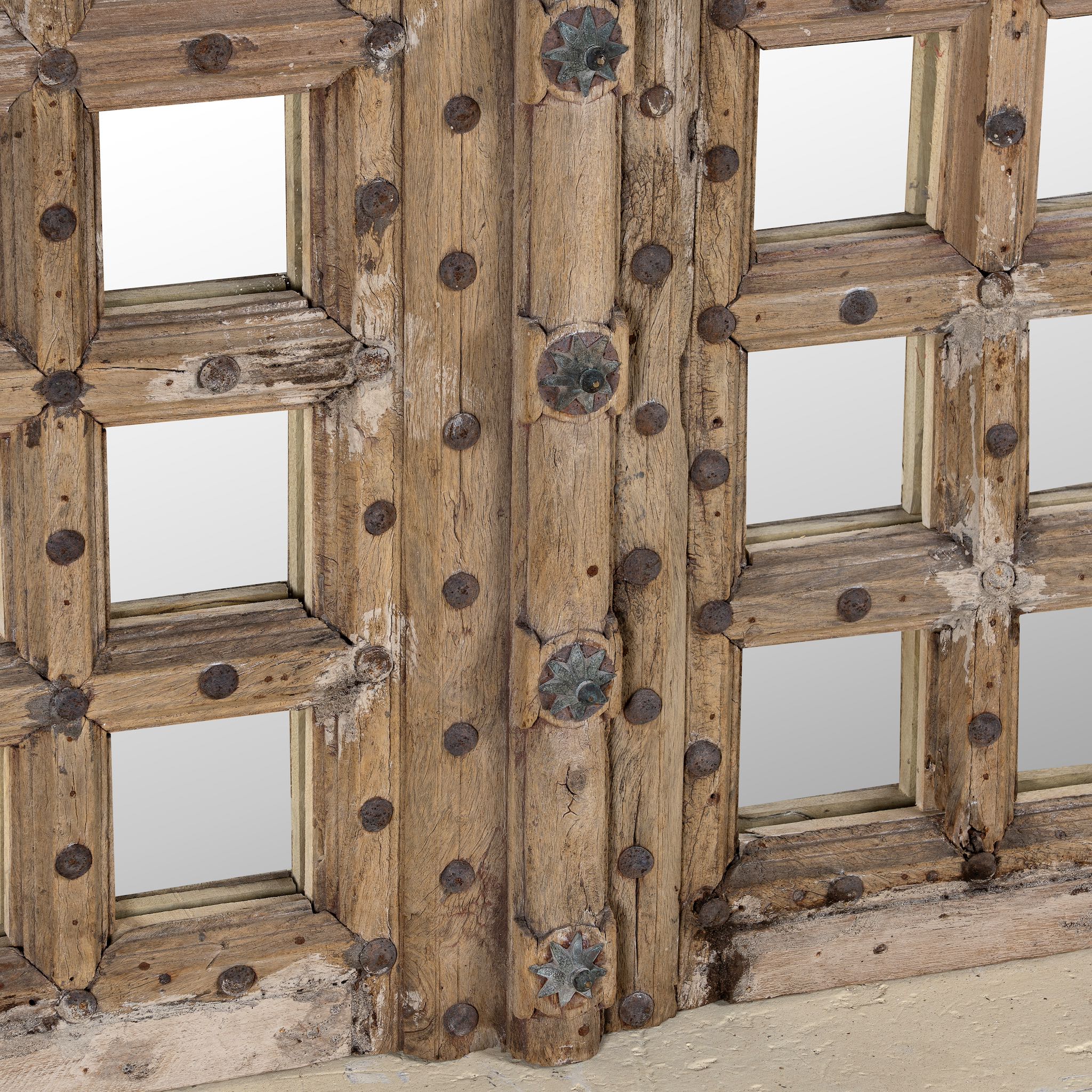 Close-up of a wooden door mirror made from antique teak, part of our Indian home decor collection with original carvings and iron accents.