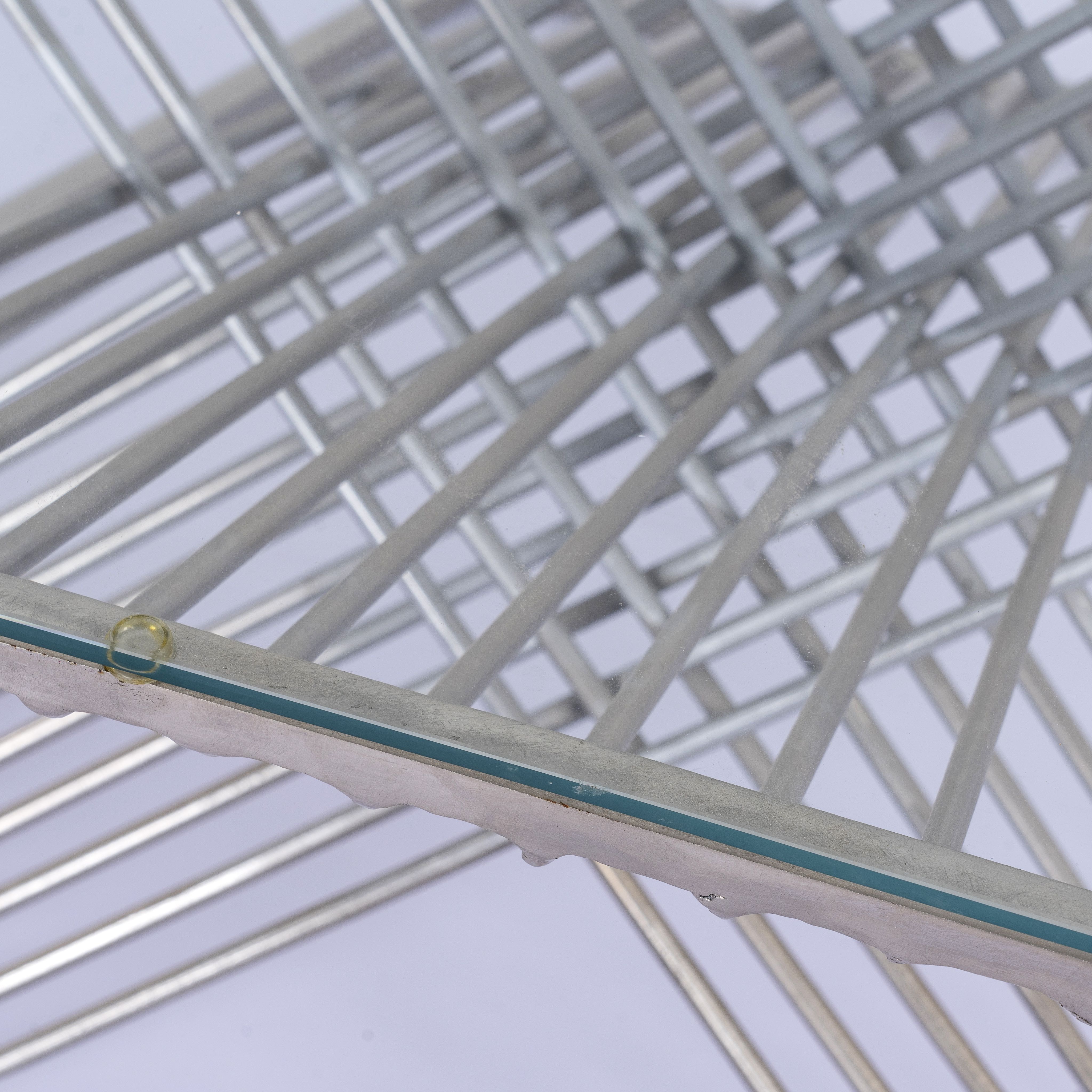 Close up image of a hexagonal wire metal base coffee table with glass top; modern coffee table industrial style, 92 × 80 × 46 cm.