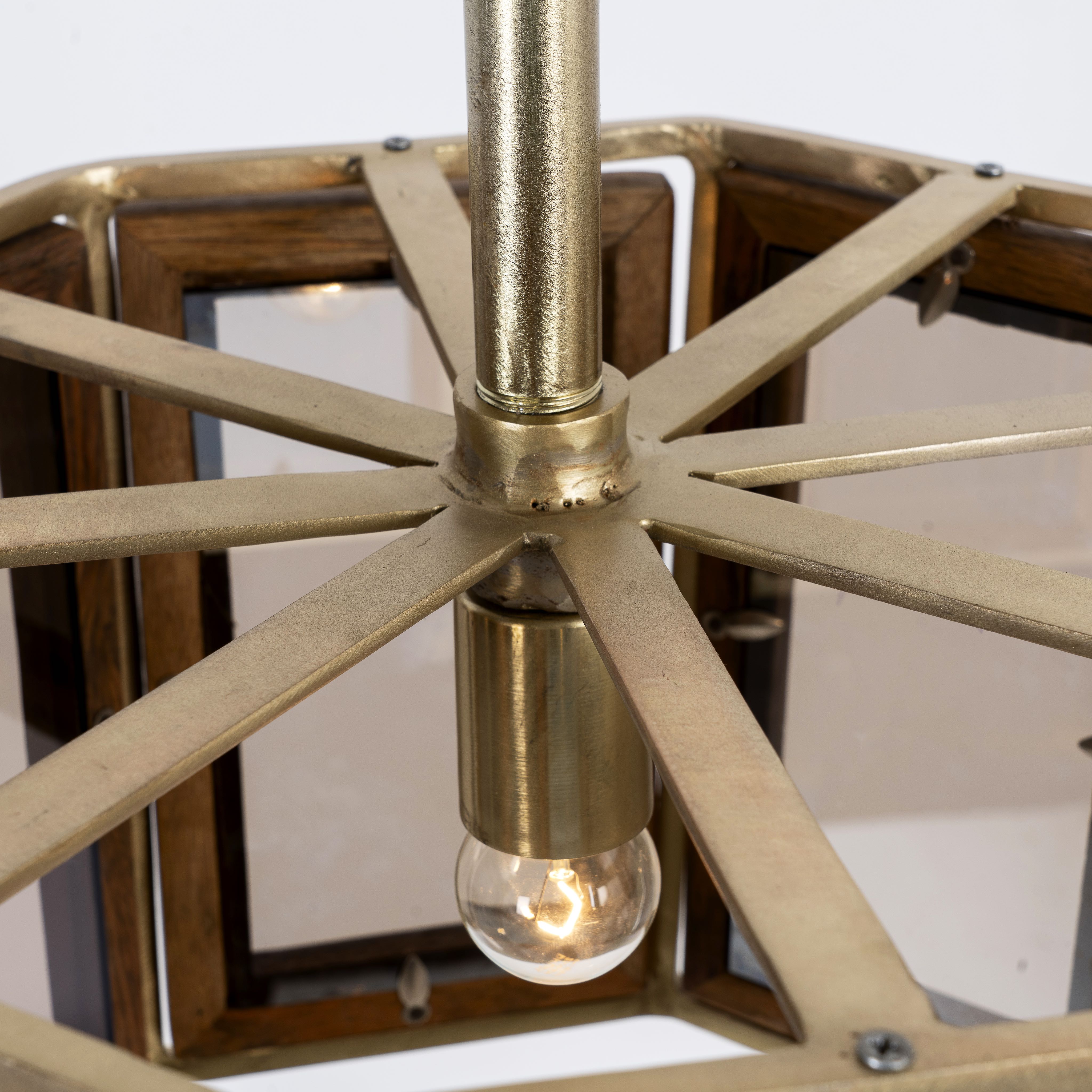 Close up image of a octagon-shaped mango wood pendant lamp with antique brass finish – handcrafted wooden lamp ideal for industrial style lighting in compact interiors.