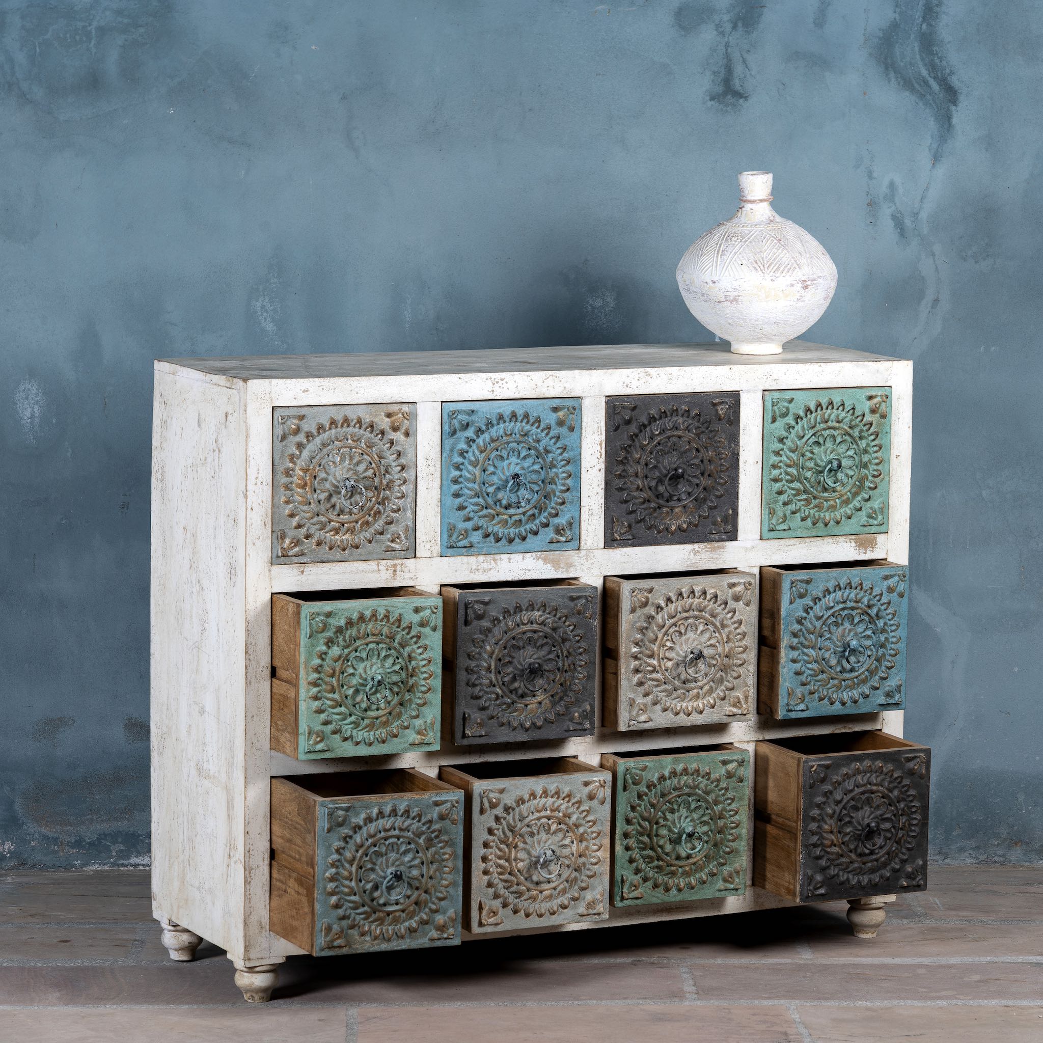 Image with open drawers of a carved mango wood chest of drawers with twelve multicolour floral drawer fronts, 124 × 40 × 102 cm.