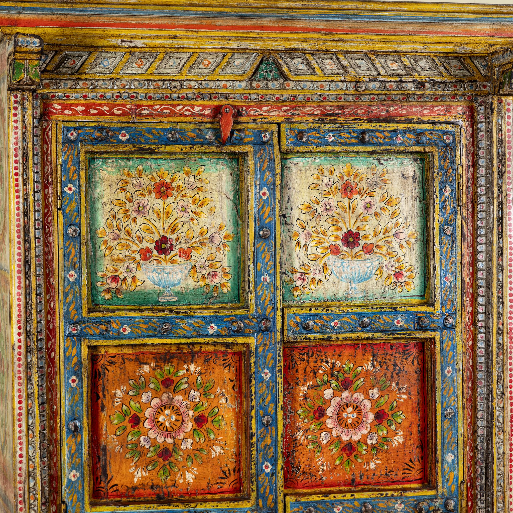 Close up image of a hand-painted teak wood cabinet with floral motifs; teak wood furniture for bohemian interiors, 105 × 55 × 177 cm.