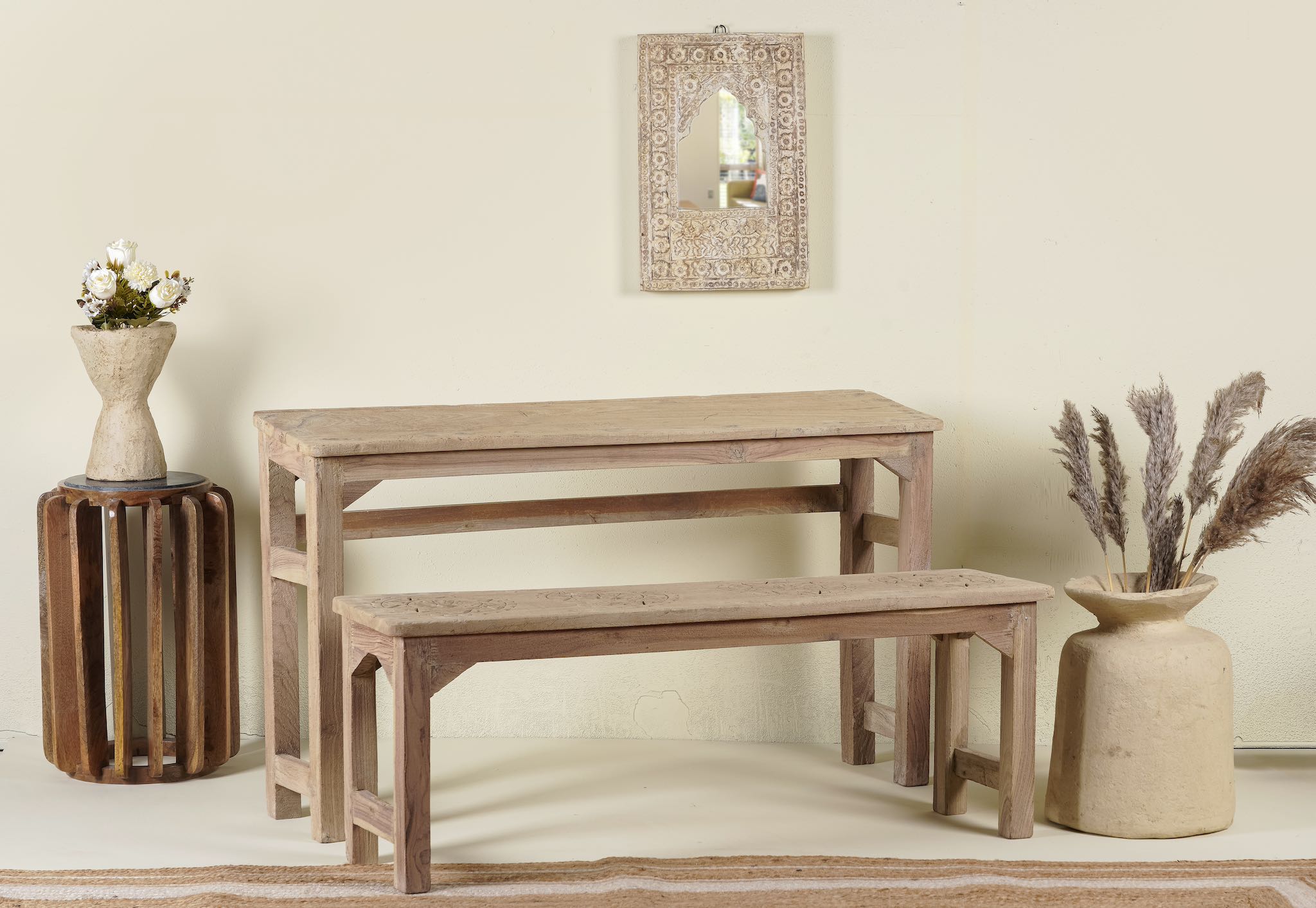Side angle image of a Vintage school bench set from India, crafted from old teak wood, featuring a simple, sturdy design with a long bench and matching table in a natural, weathered finish, styled in a neutral-toned interior with rustic decor accents.