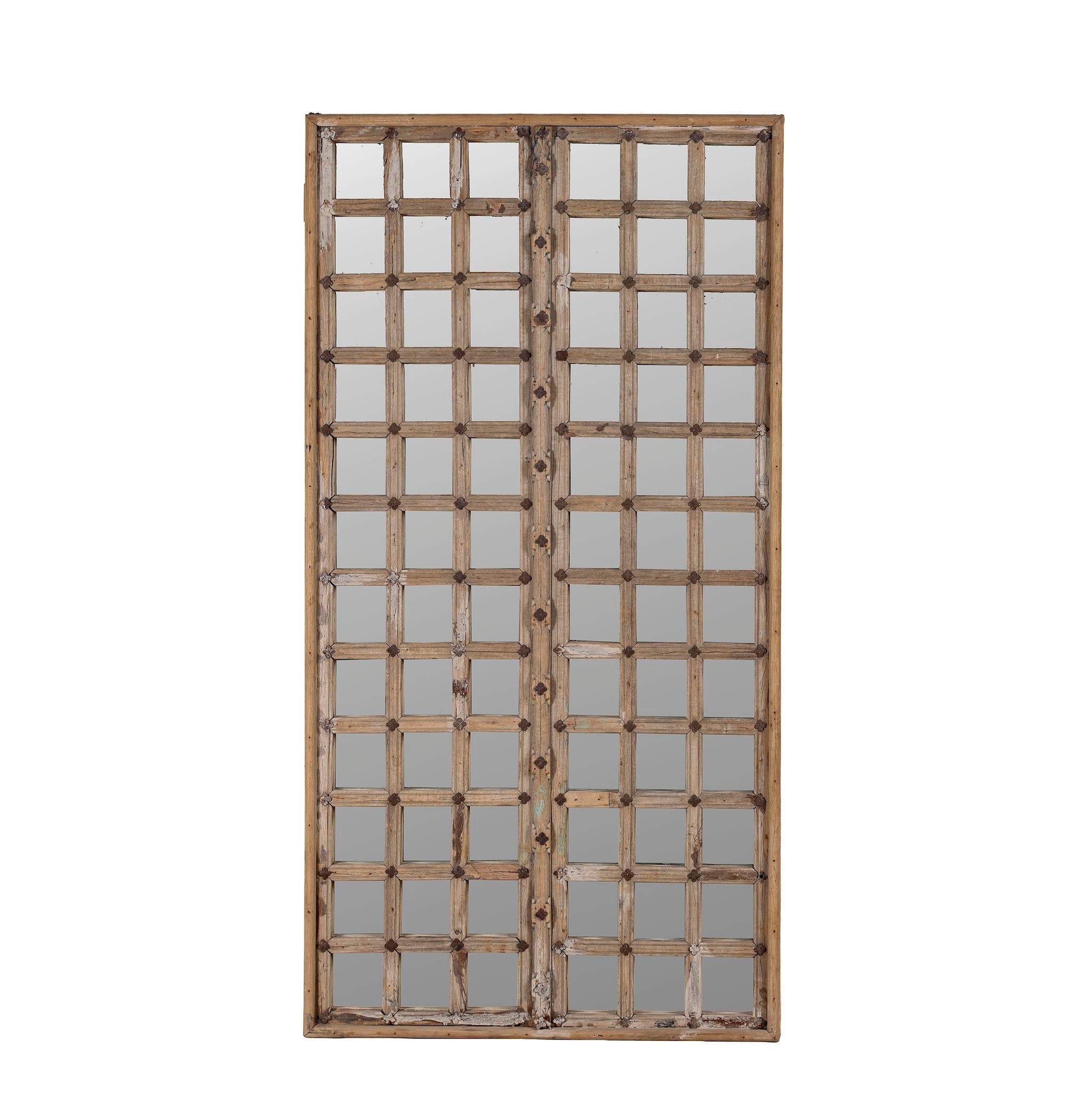 White background picture of a antique teakwood mirror made from a traditional Indian door with iron details and mirror inlays – perfect as a reclaimed wood mirror for vintage home decor.